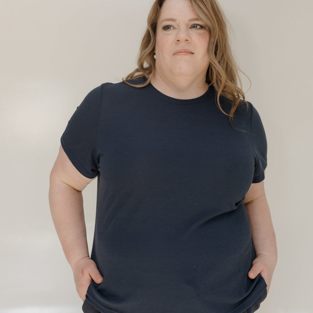 Person wearing a navy blue t-shirt and pants against a plain background