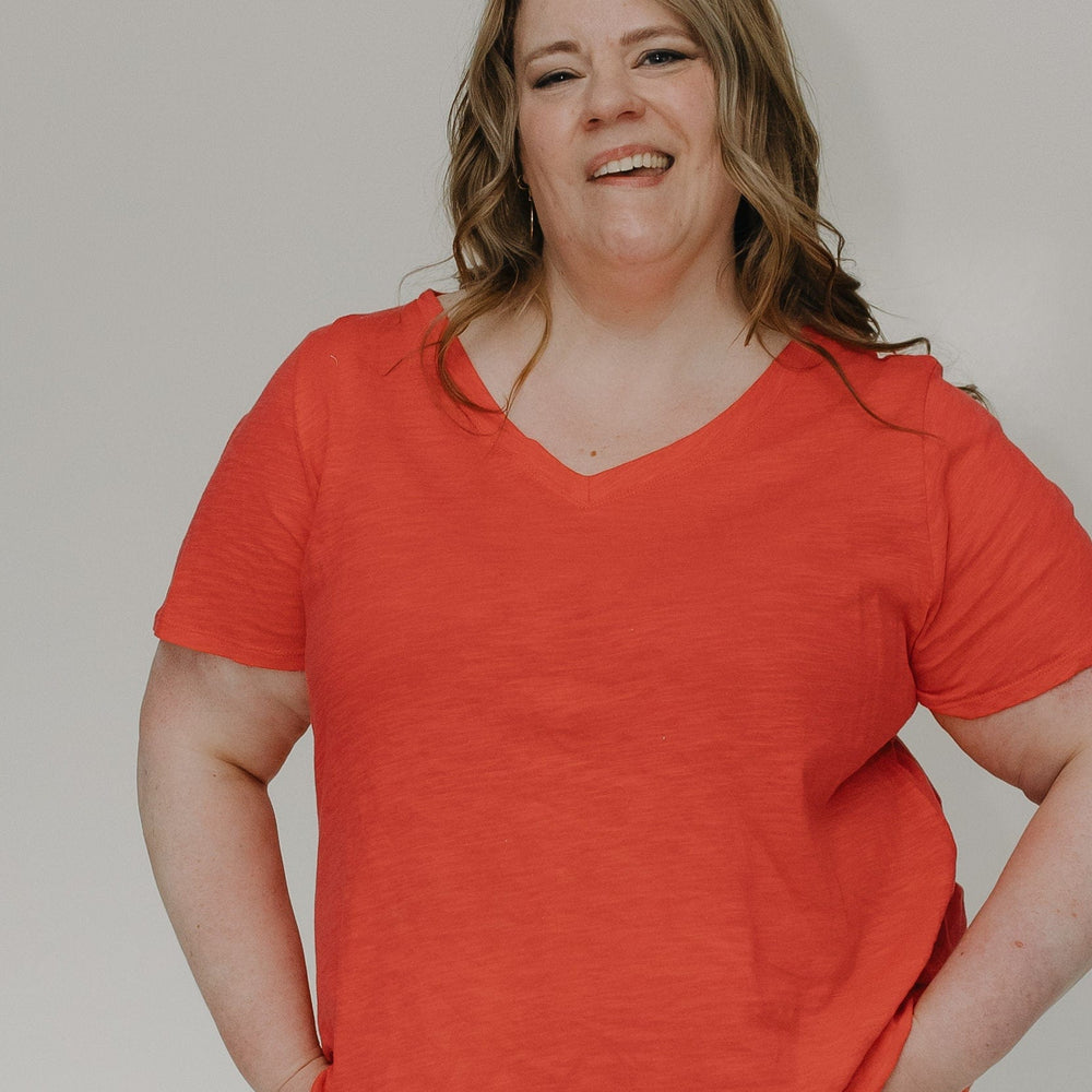 Person wearing a red shirt against a plain background