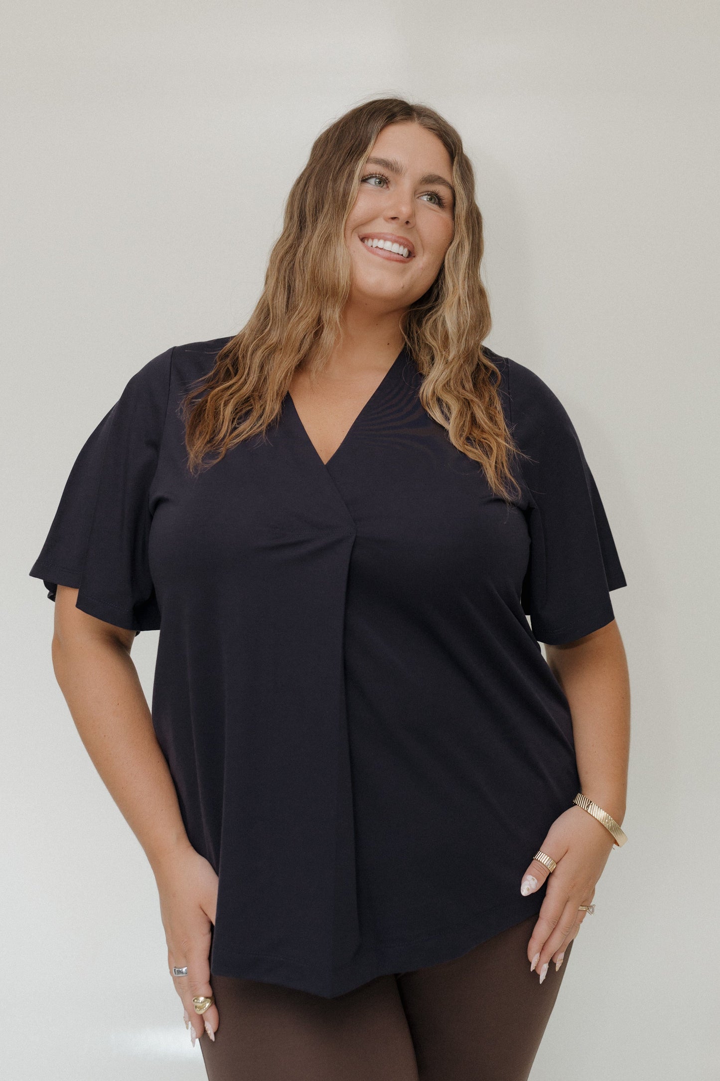 Woman wearing a black top against a plain background