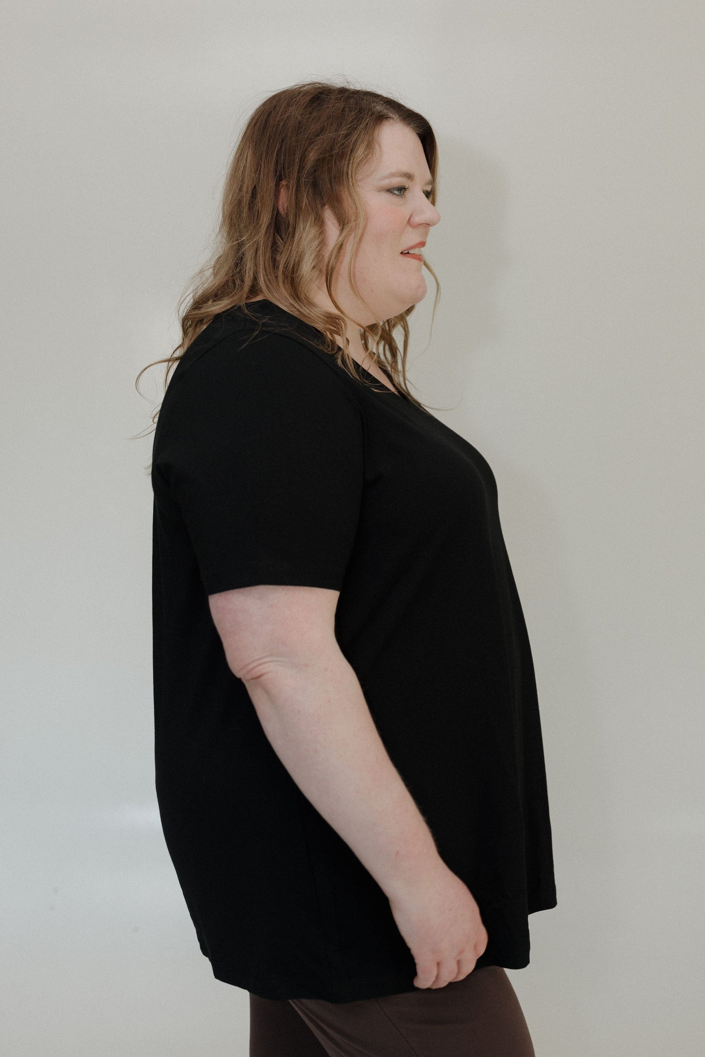 Person wearing a black t-shirt against a plain background