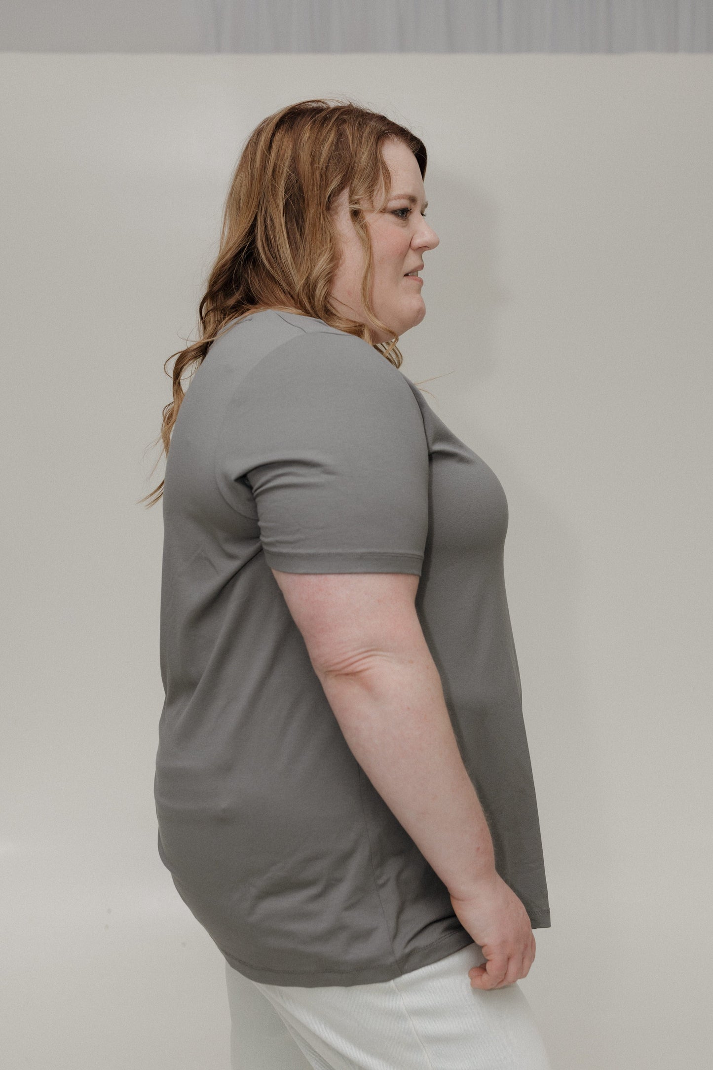Woman wearing a gray t-shirt against a plain background