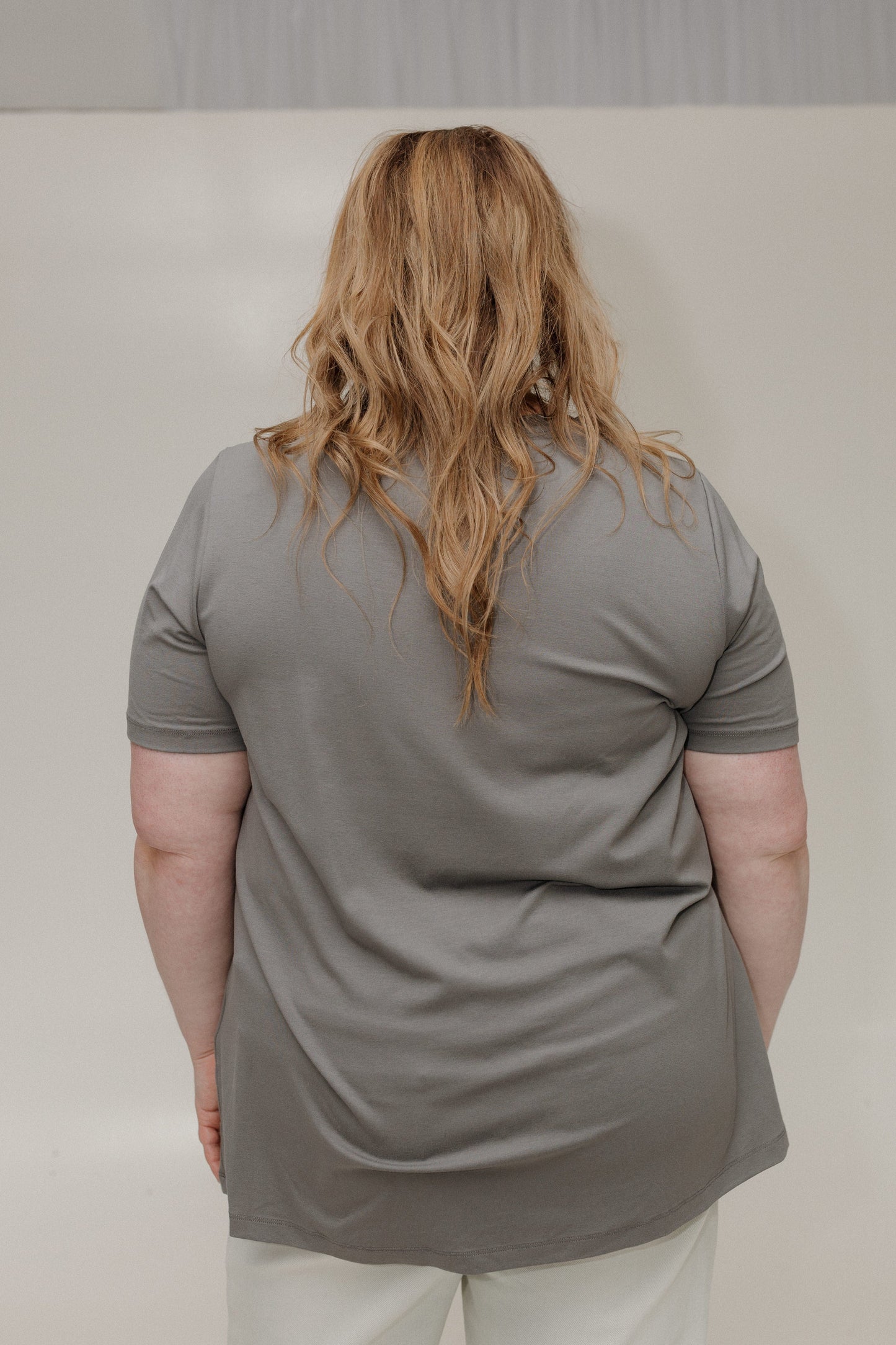 Person wearing a gray polo shirt against a plain background