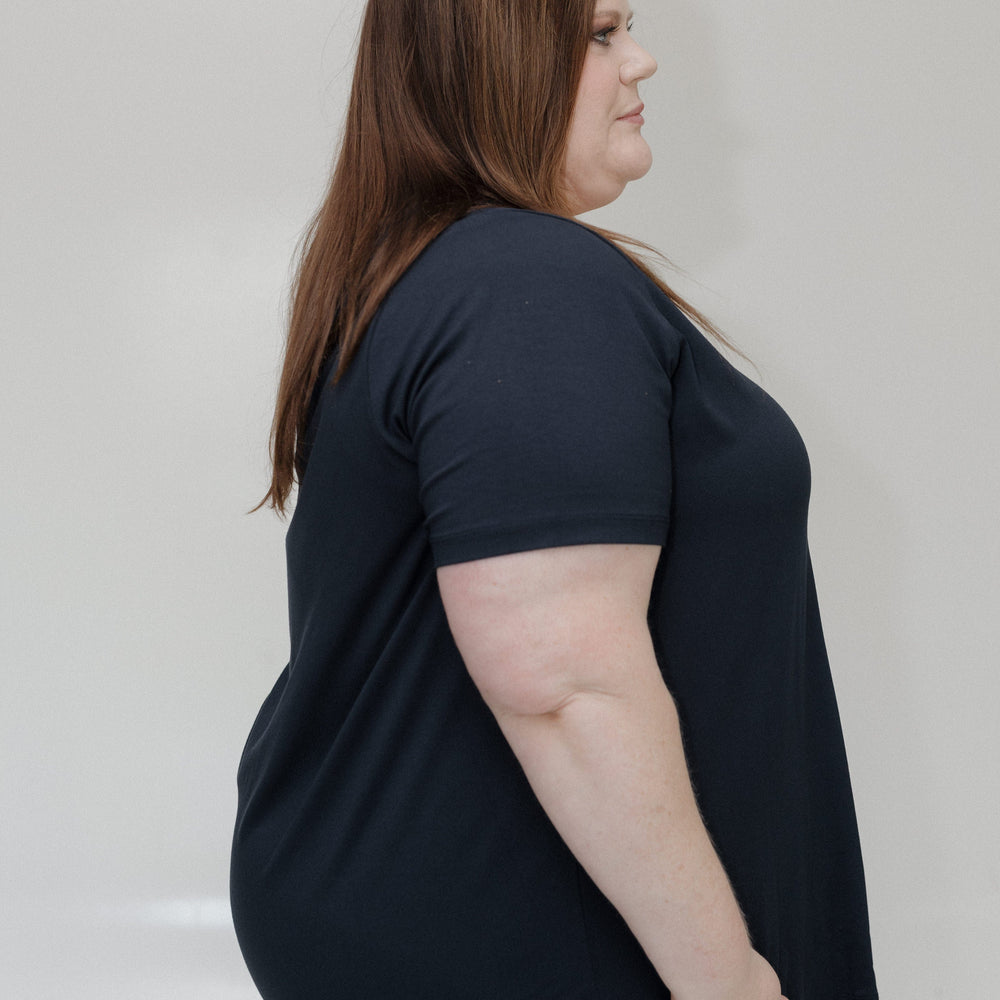 Woman wearing a black t-shirt against a plain background