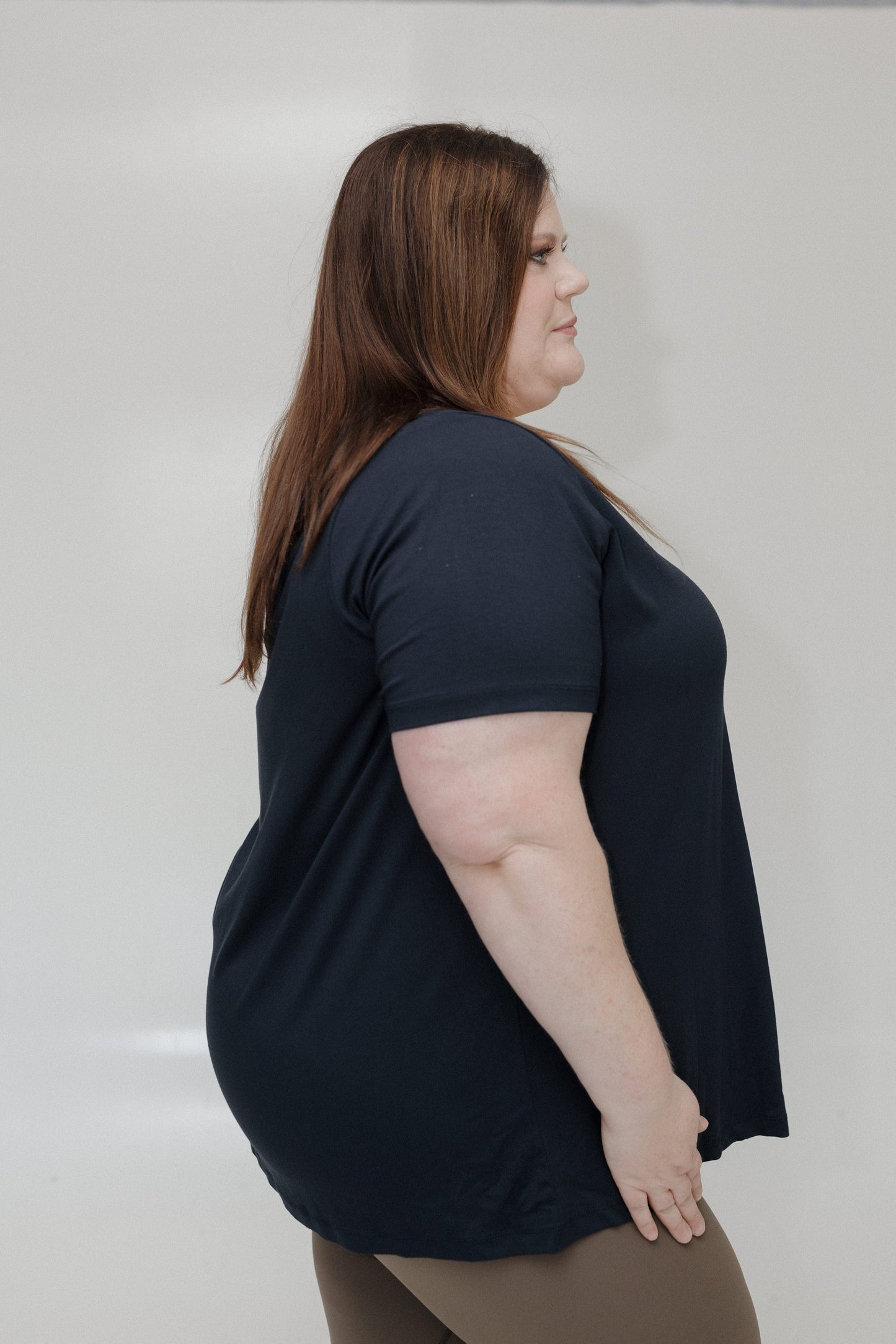Woman wearing a black t-shirt against a plain background