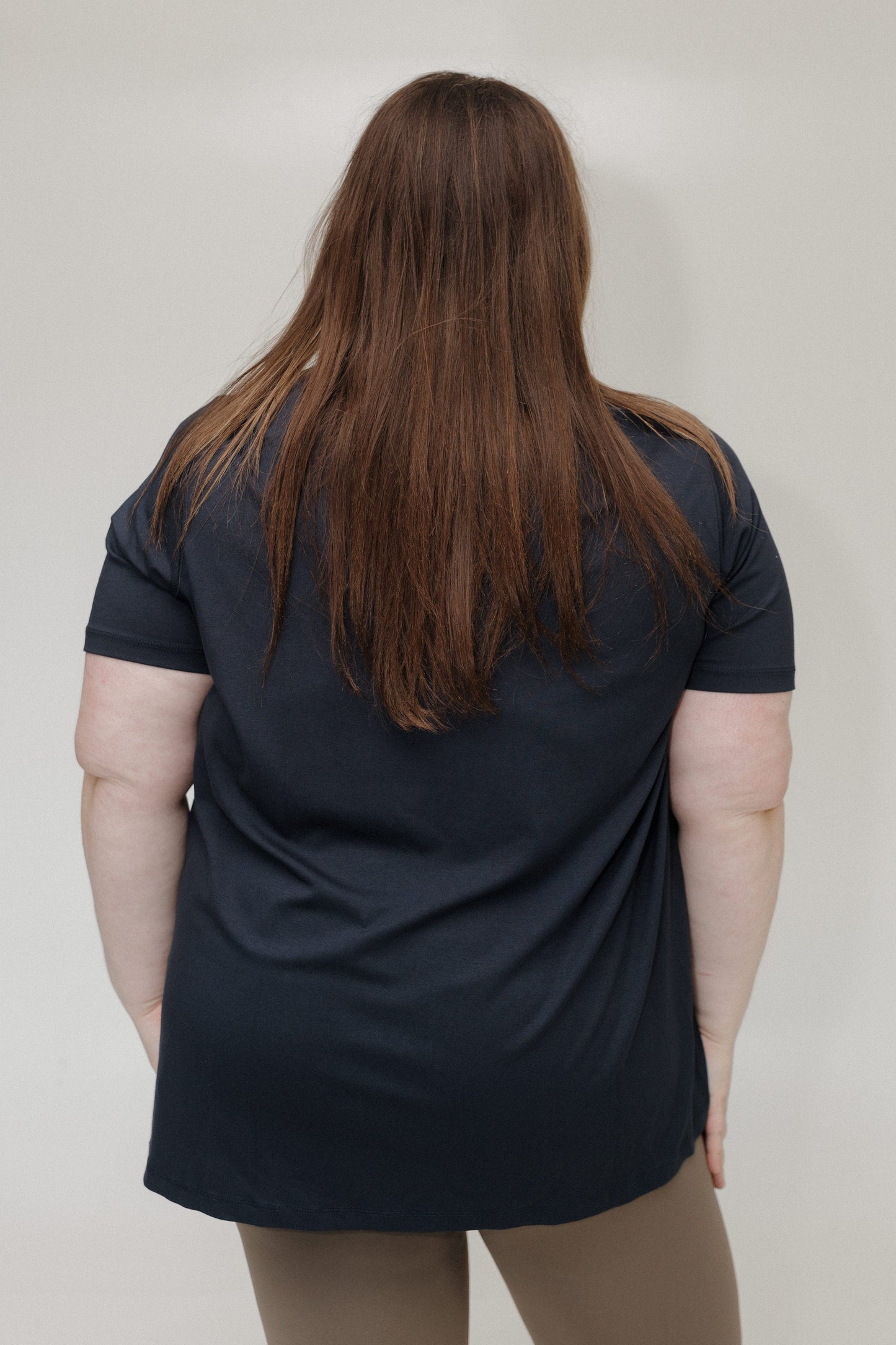 Person wearing a black t-shirt against a plain background