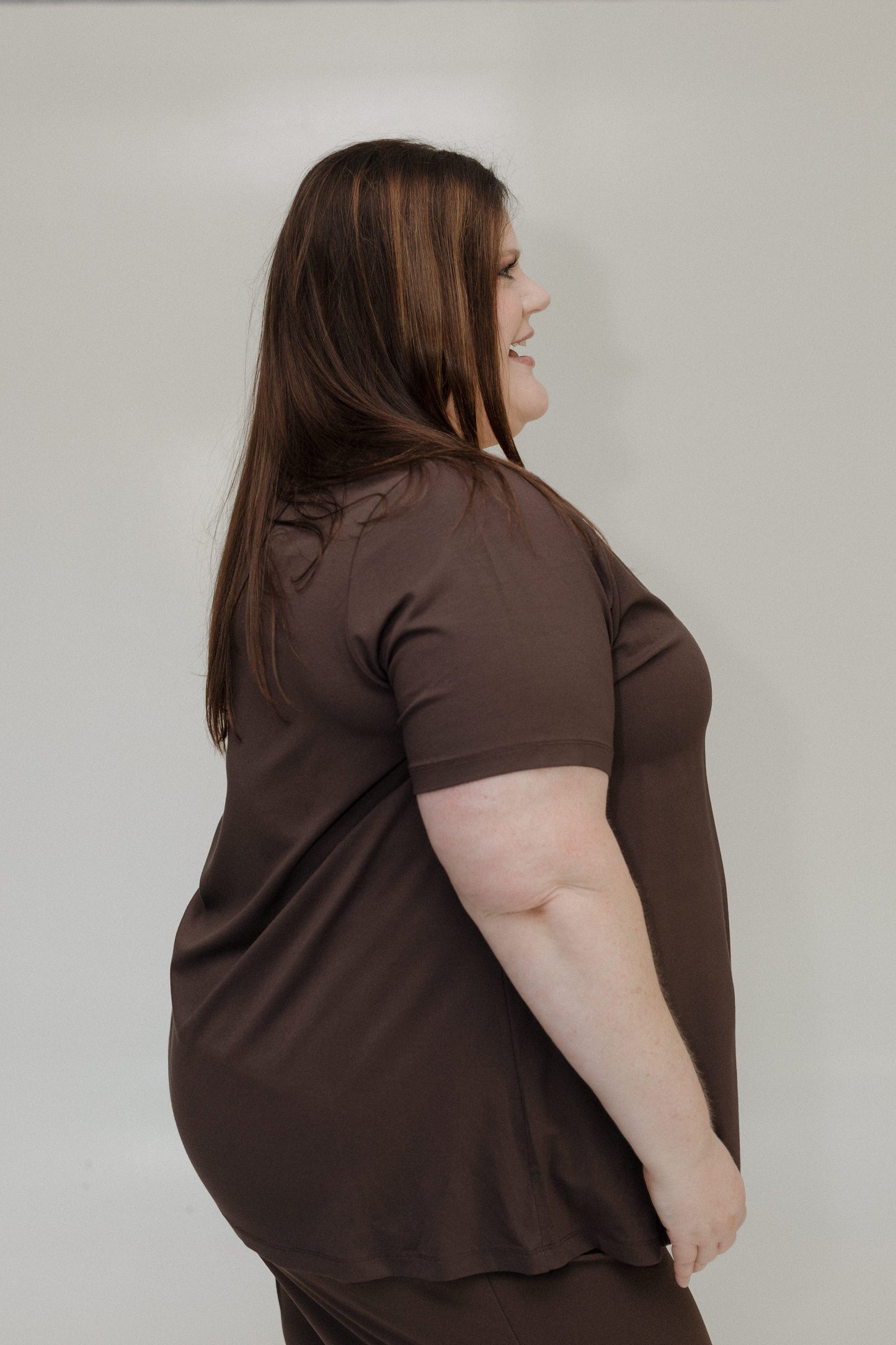 Woman wearing a brown shirt against a plain background