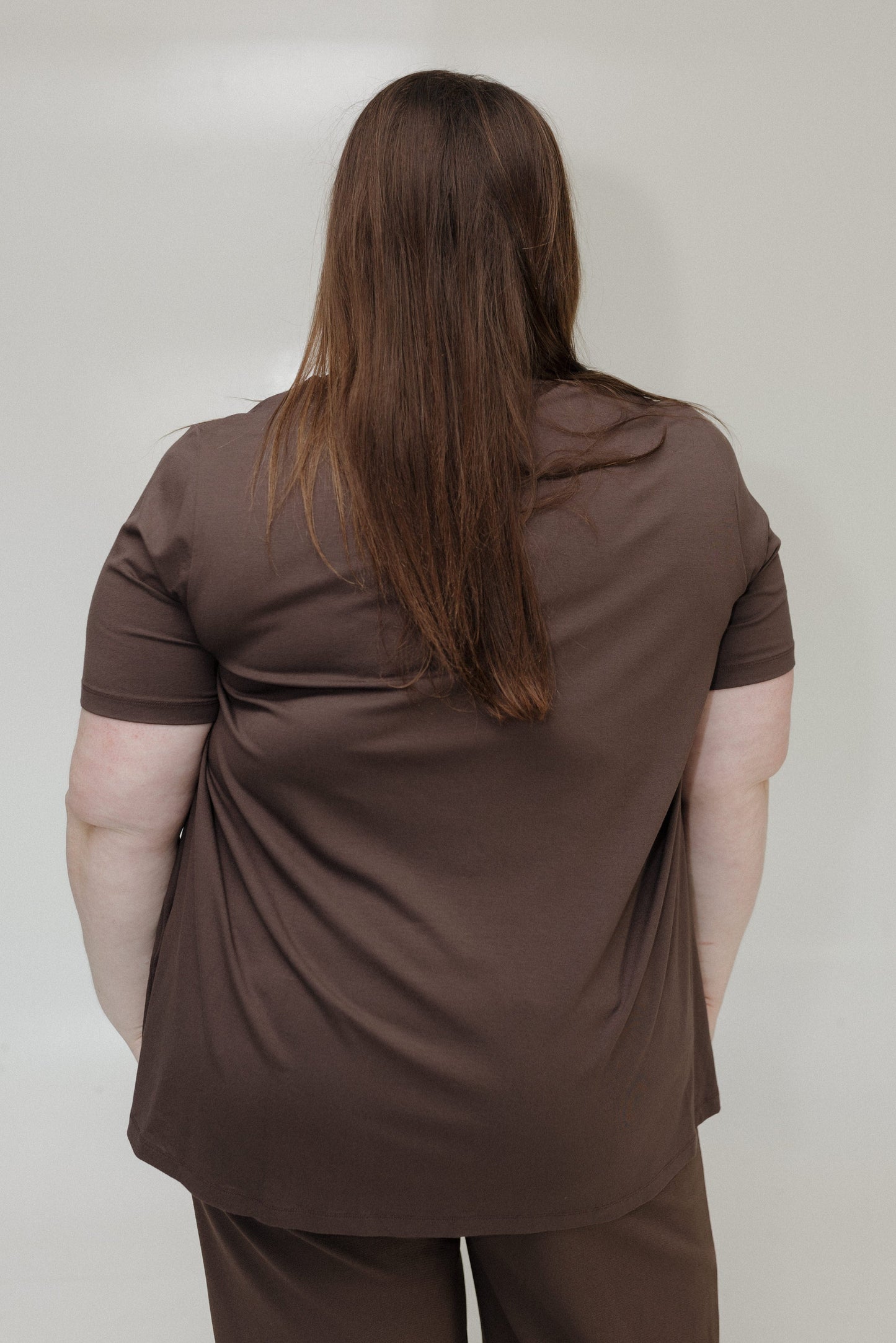 Person wearing a brown outfit against a plain background