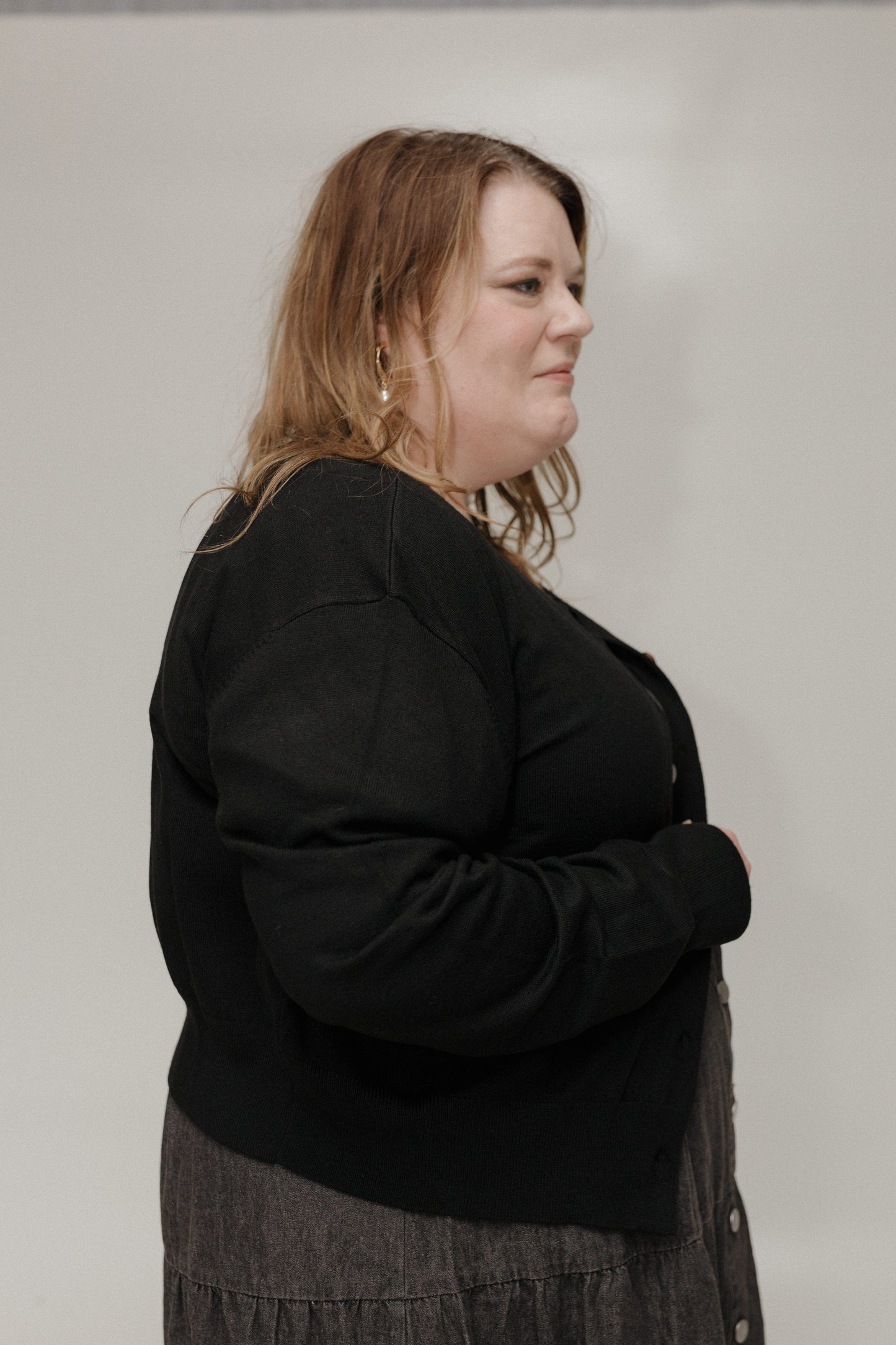 Woman wearing a black sweater against a plain background