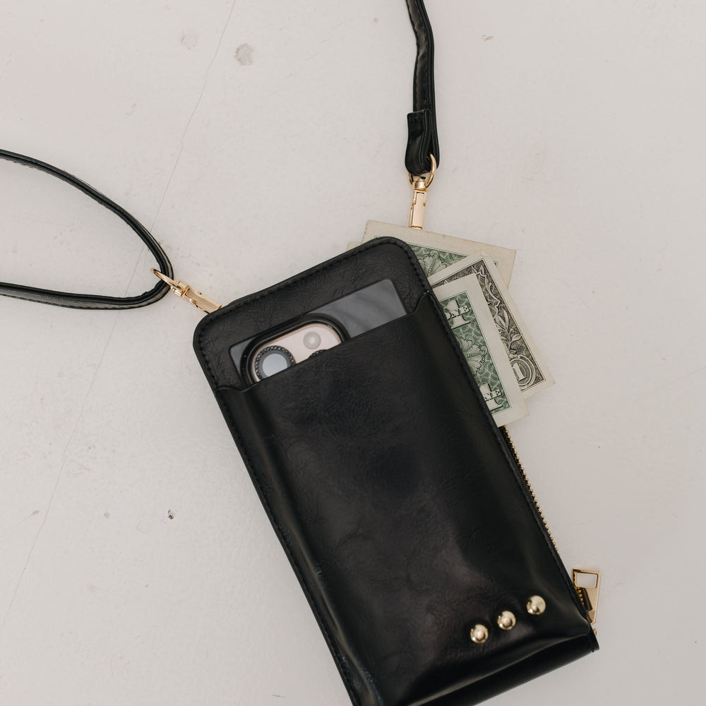 Black phone pouch with a strap on a light gray surface