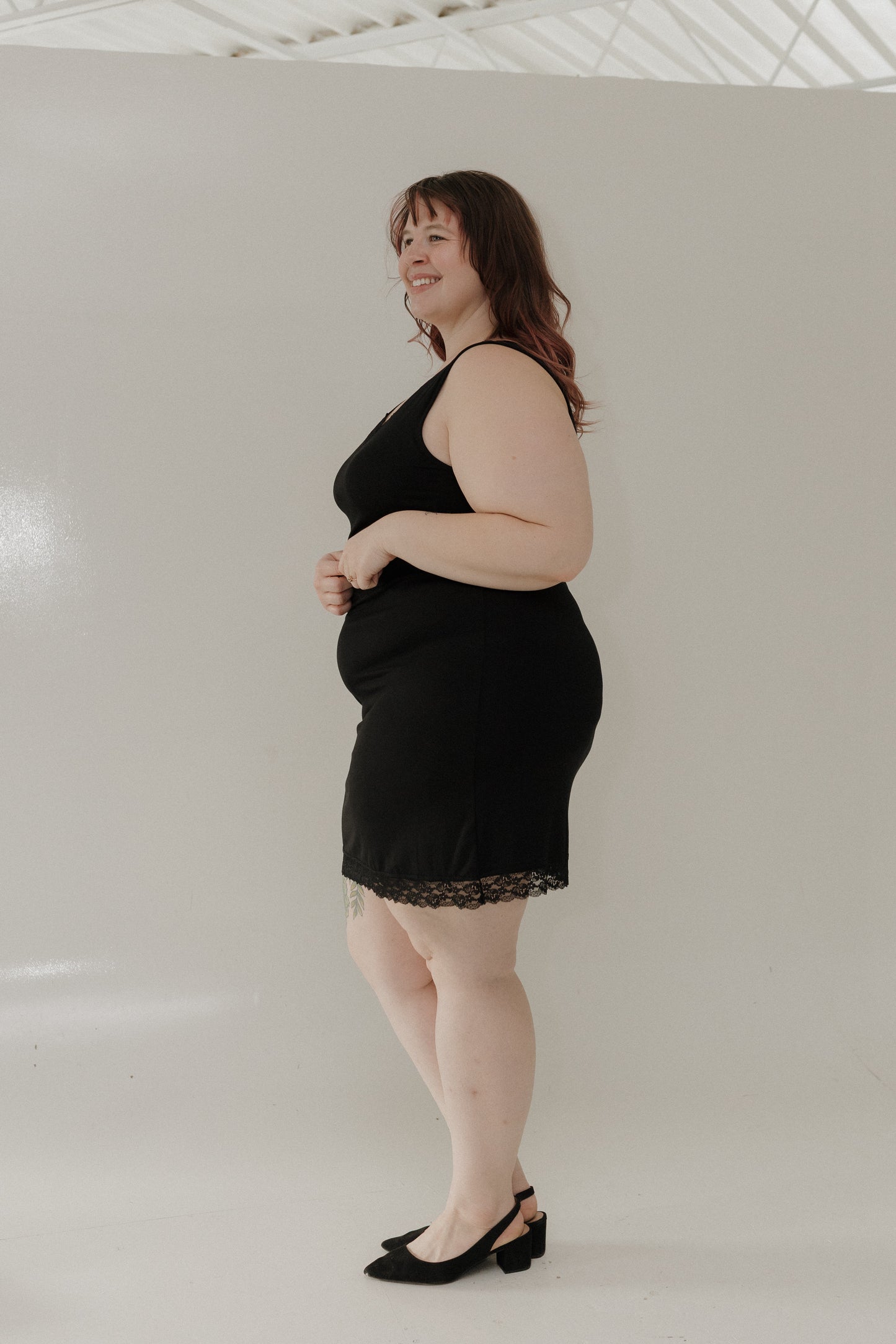 Woman wearing a black dress with a plain white background