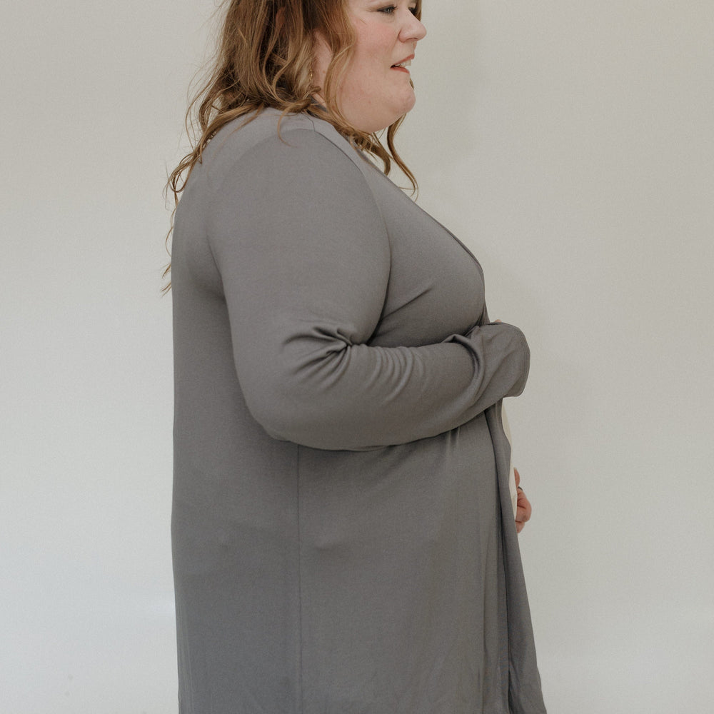 Woman wearing a gray cardigan against a white background