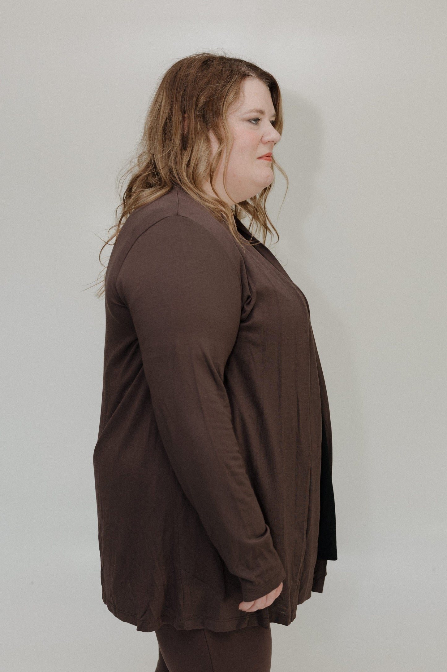 Woman wearing a brown outfit against a plain background