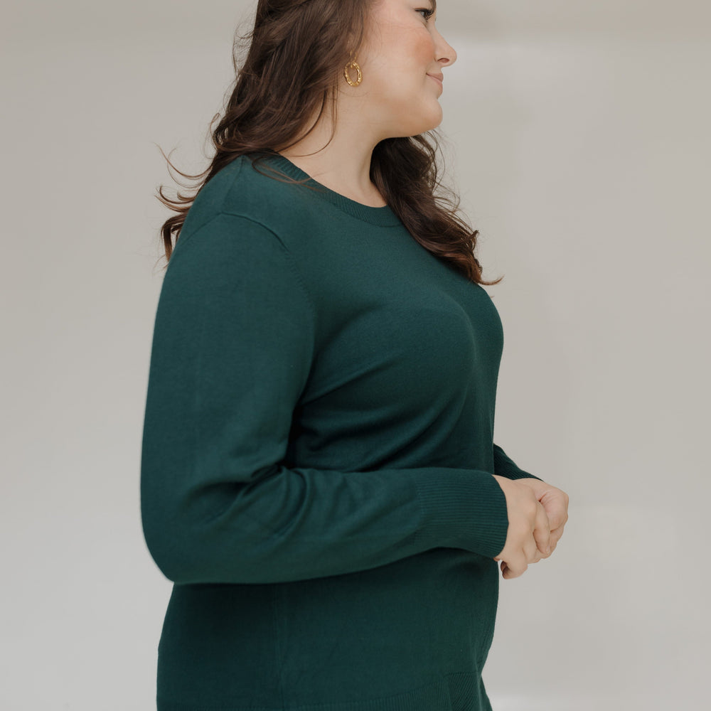 Woman wearing a green sweater against a plain background