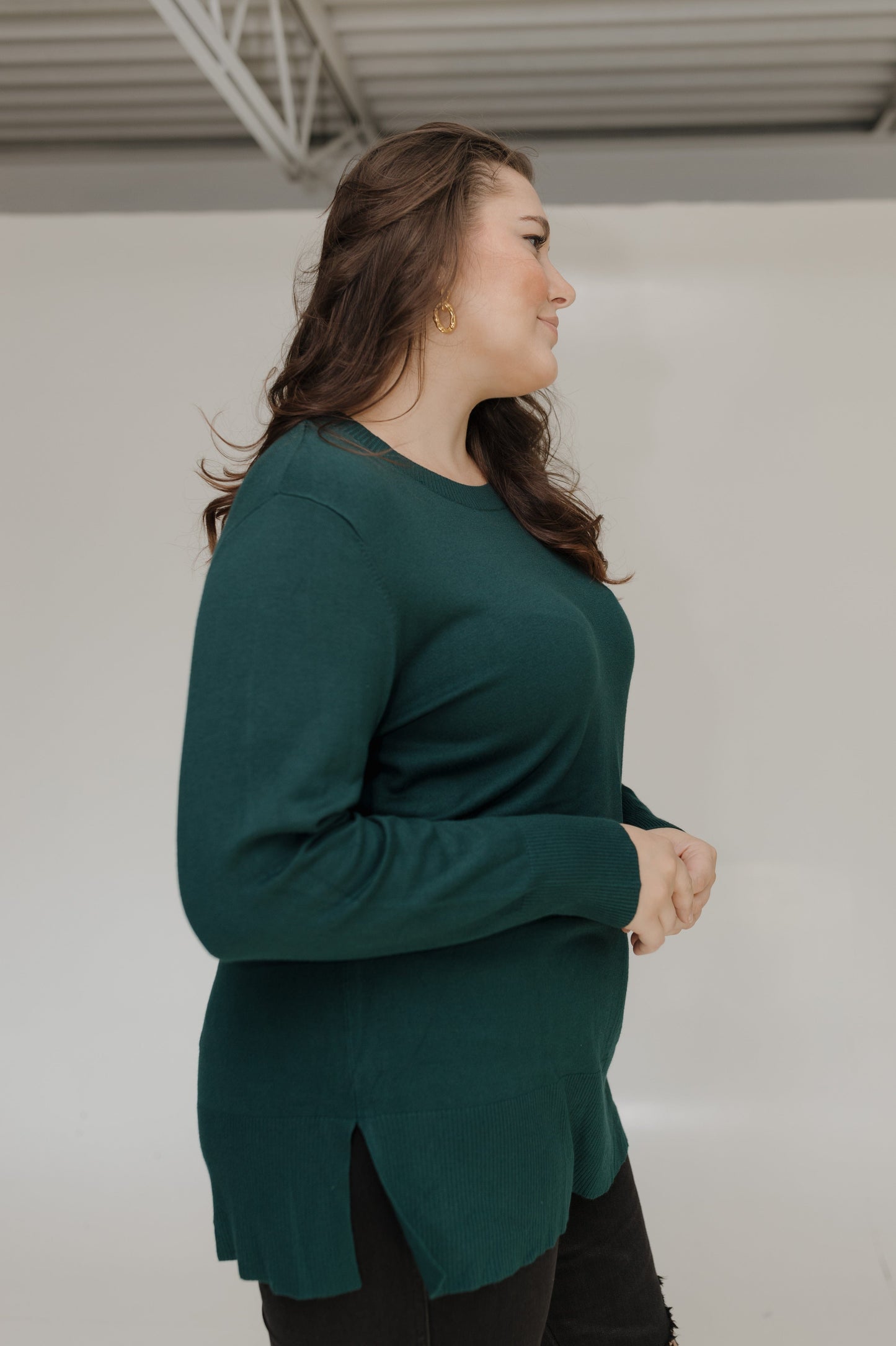 Woman wearing a green sweater against a plain background
