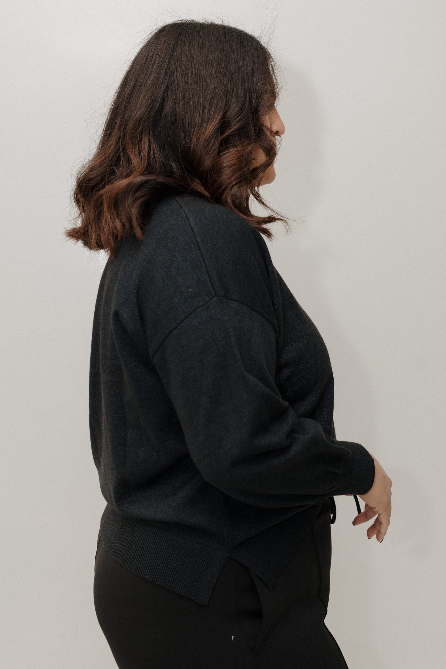 Person wearing a black outfit against a plain background
