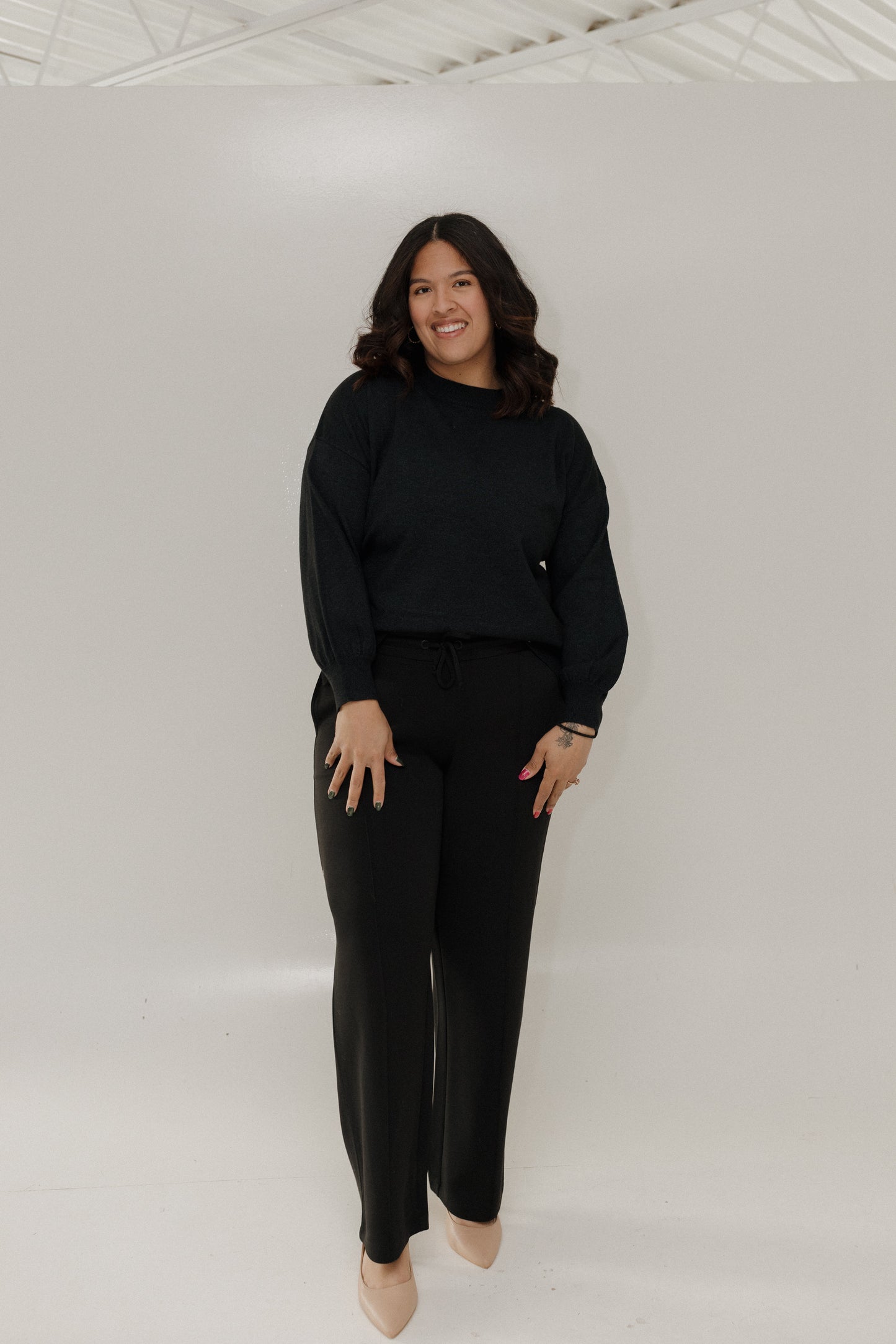 Woman wearing a black outfit against a white background