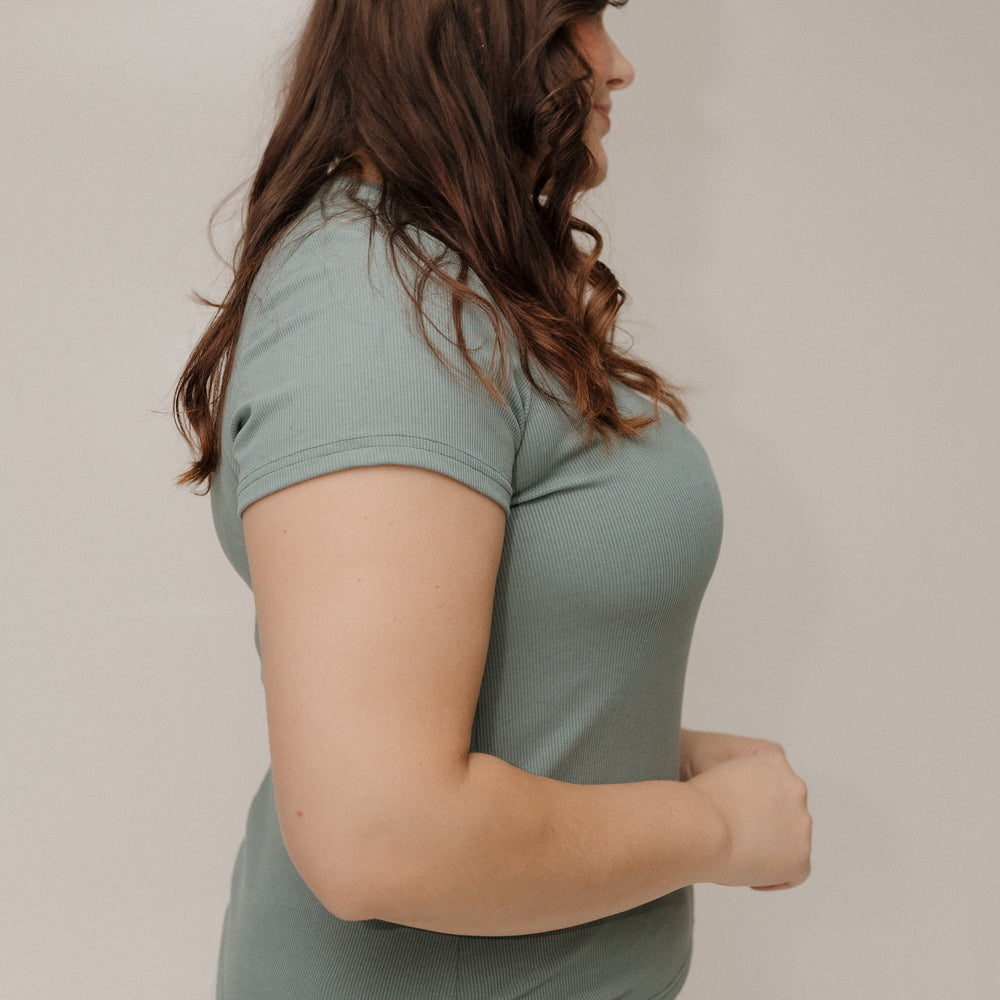 Woman wearing a green t-shirt against a plain background