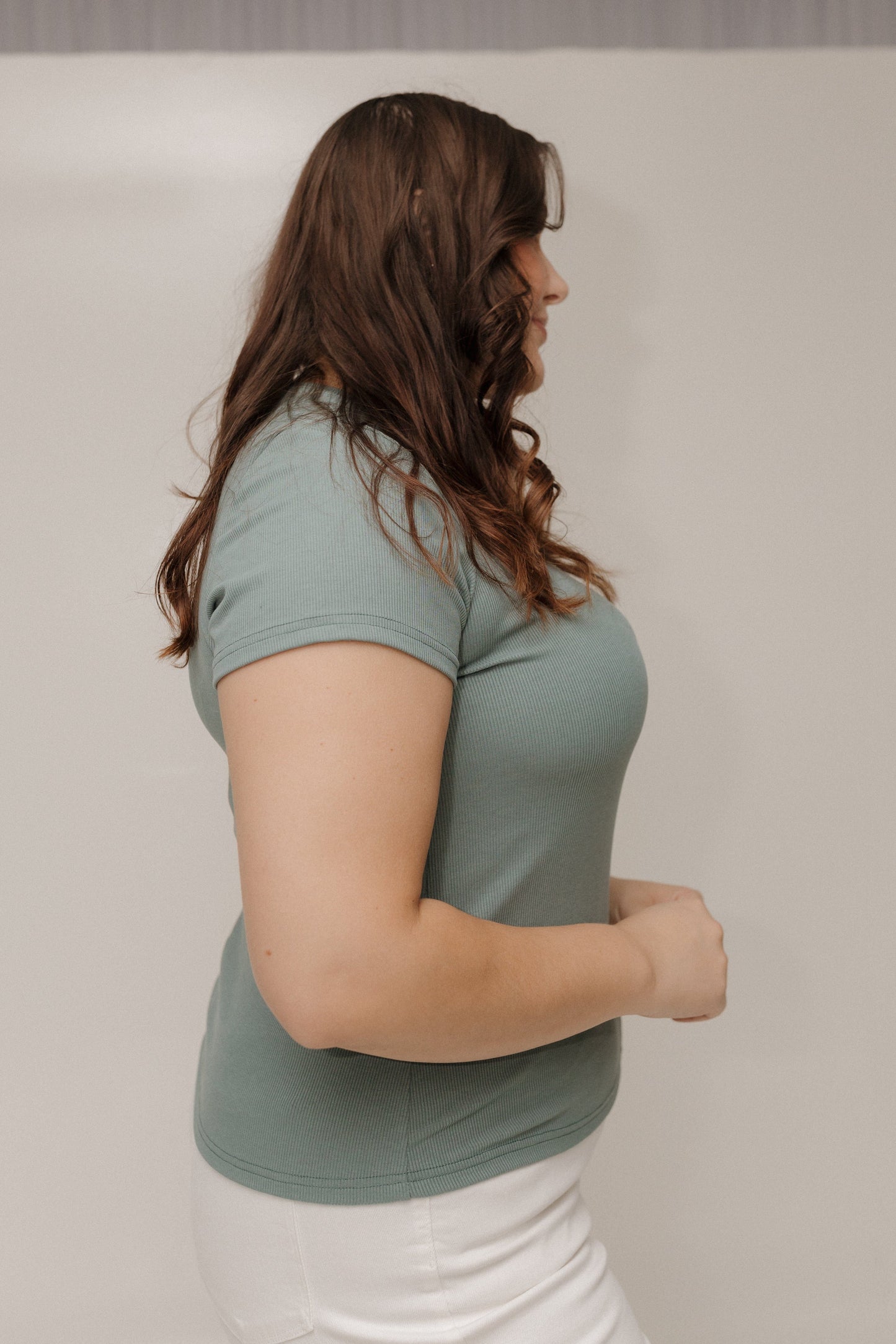 Woman wearing a green t-shirt against a plain background
