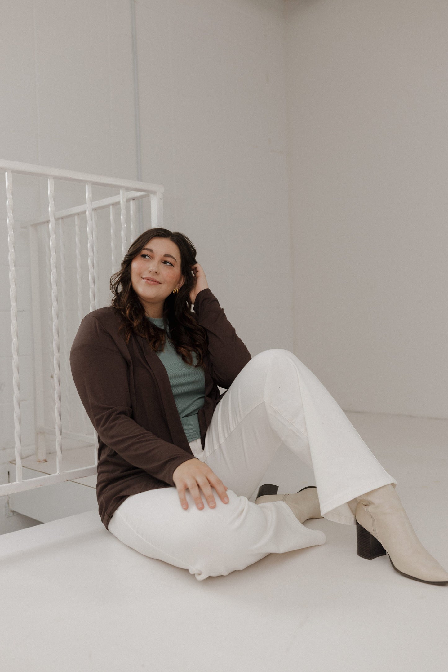 Woman sitting on a bed in a minimalistic room