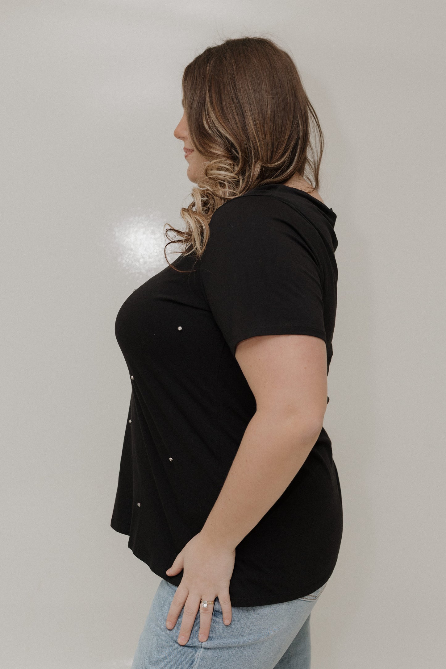 Woman wearing a black top with a plain background