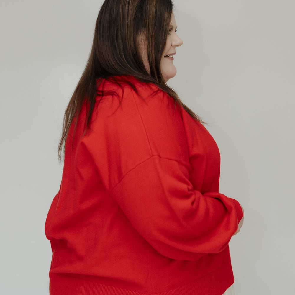 Person wearing a red jacket and white skirt against a plain background