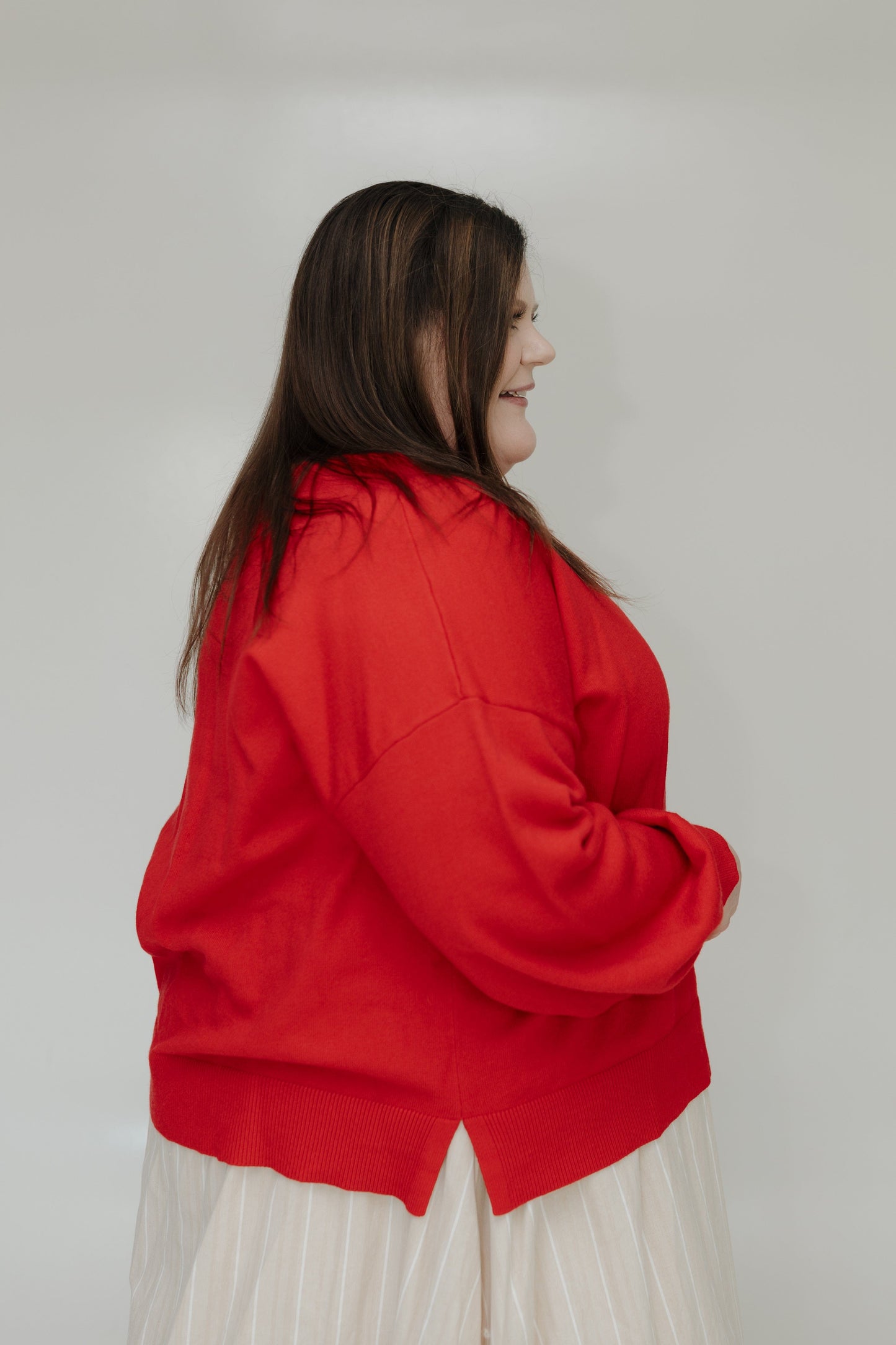 Person wearing a red jacket and white skirt against a plain background