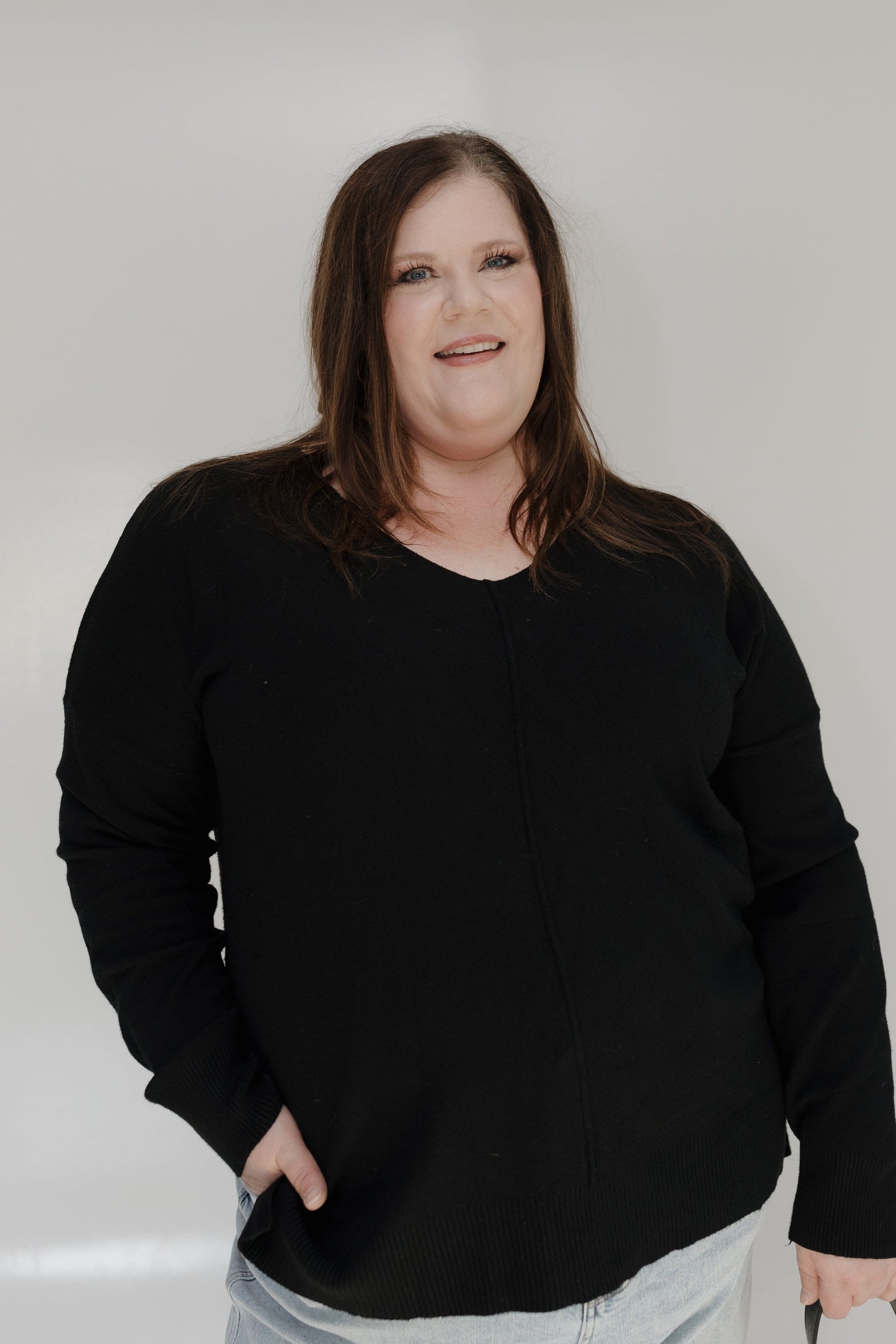 Person wearing a black sweater against a white background