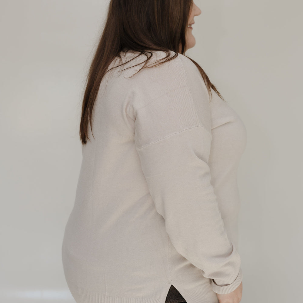 Person wearing a light-colored shirt against a plain background