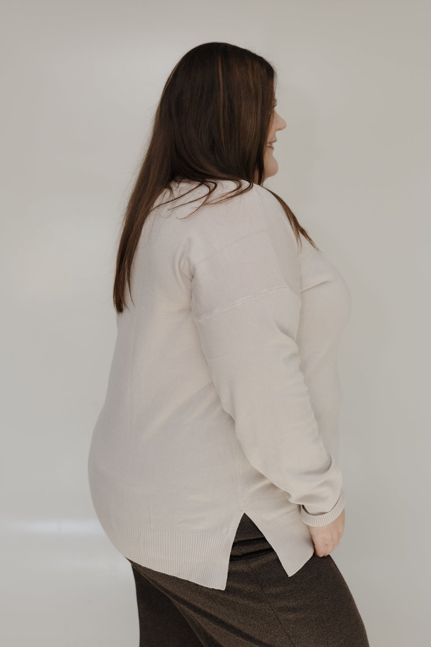 Person wearing a light-colored shirt against a plain background