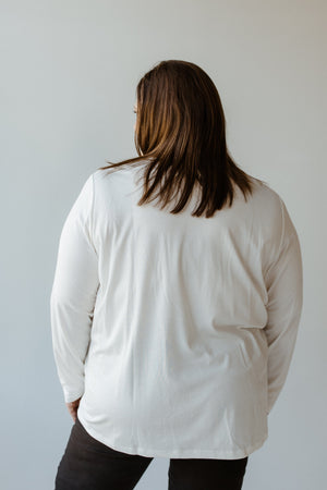 A person with long hair is wearing the ESSENTIAL V-NECK LIGHTWEIGHT BLOUSE IN ECRU by Yesta, facing away.