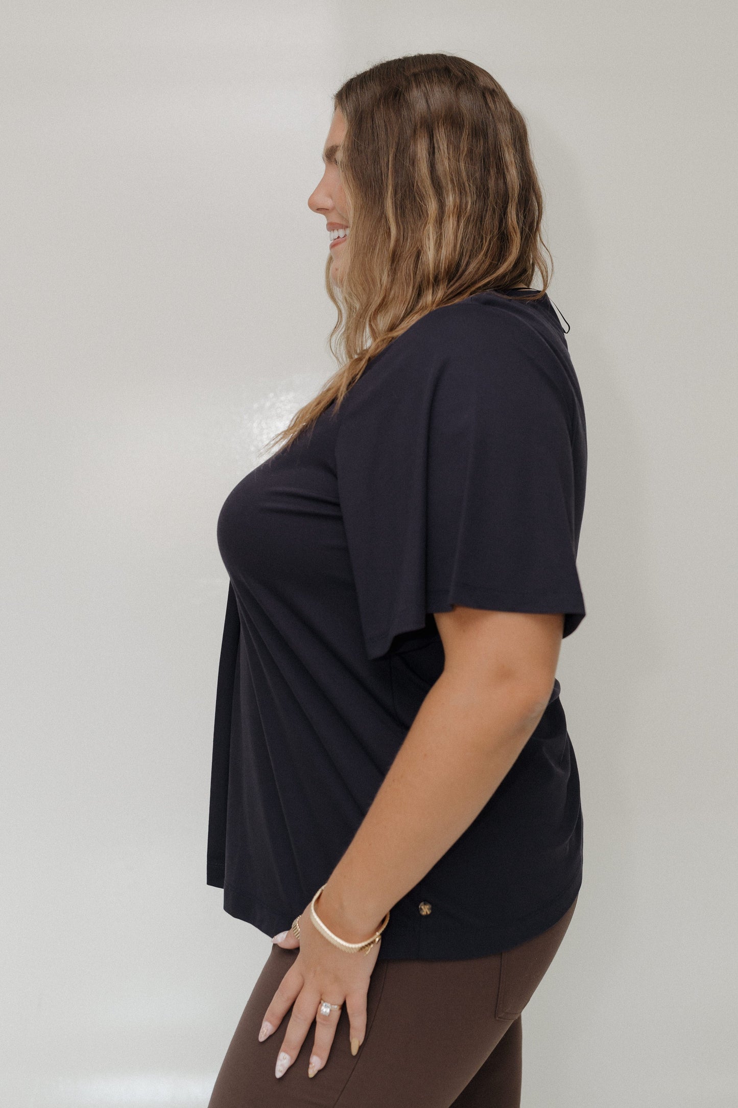 Woman wearing a black top against a plain background