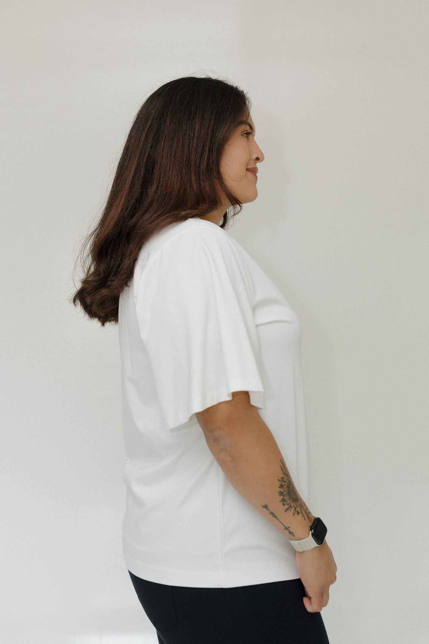 Person wearing a white t-shirt against a plain background
