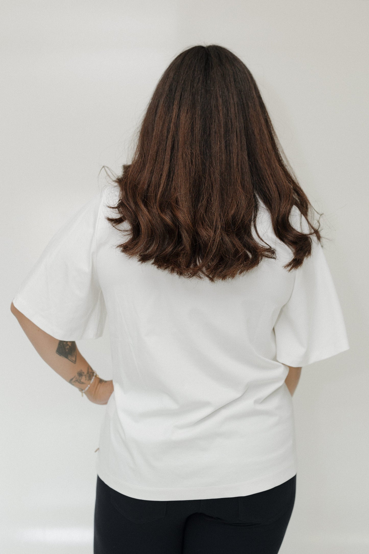 Person wearing a white t-shirt with a plain background