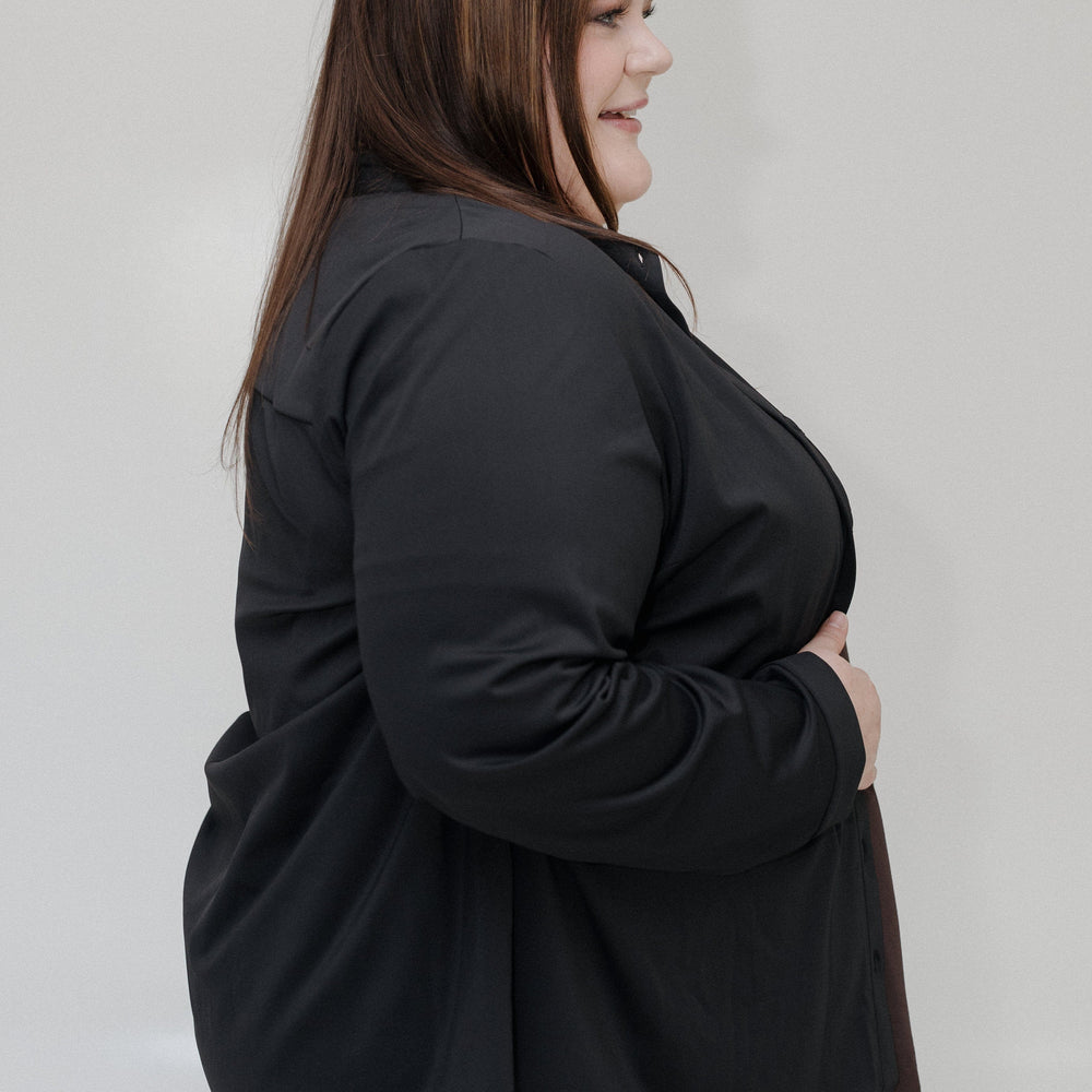 Person wearing a black jacket against a plain background