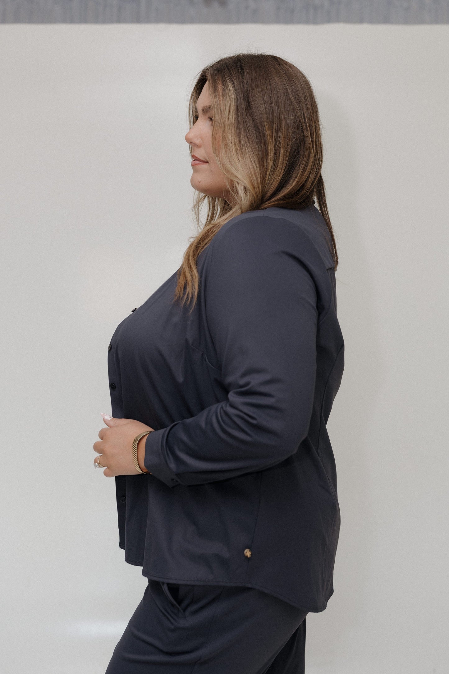 Woman wearing a dark blue outfit against a plain background