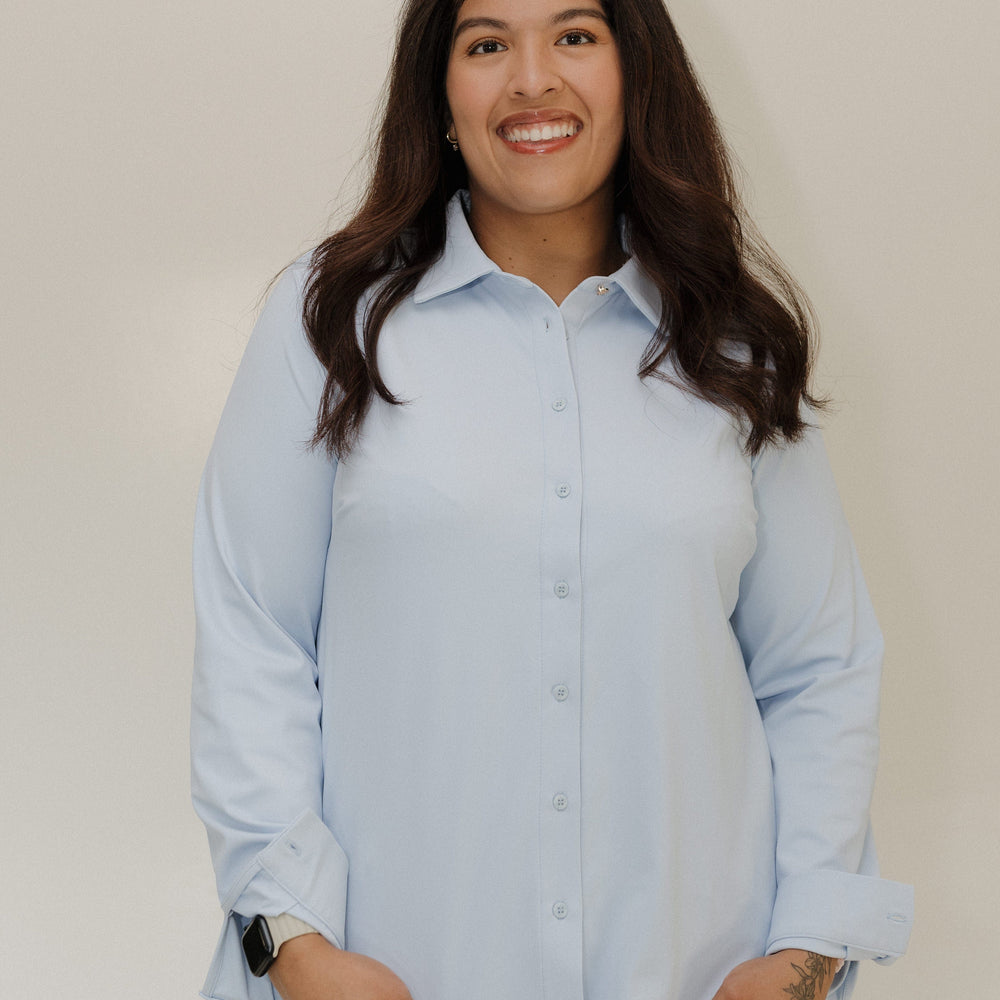 Woman wearing a light blue shirt against a plain background
