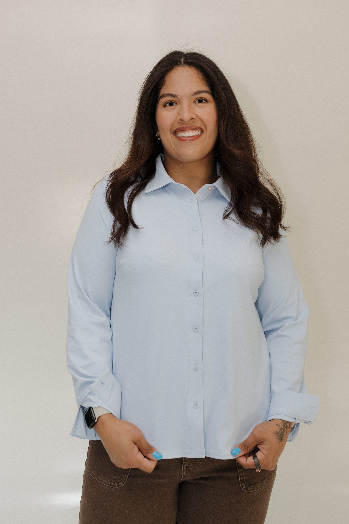 Woman wearing a light blue shirt against a plain background