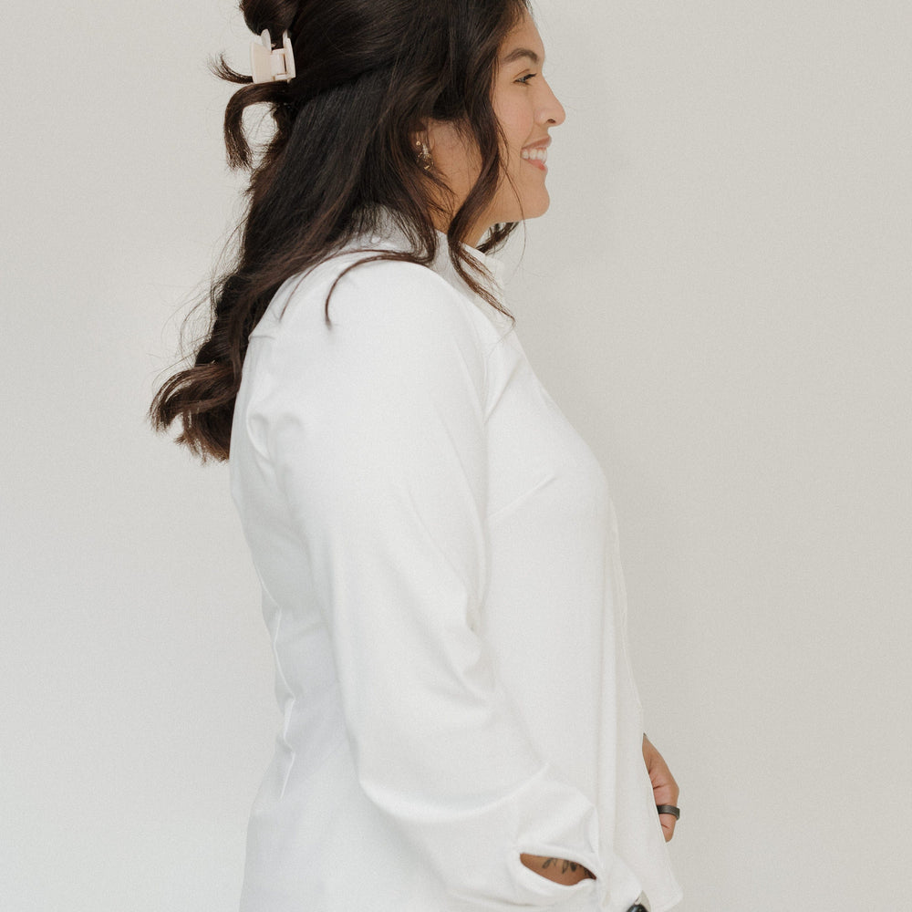 Woman wearing a white outfit against a plain background