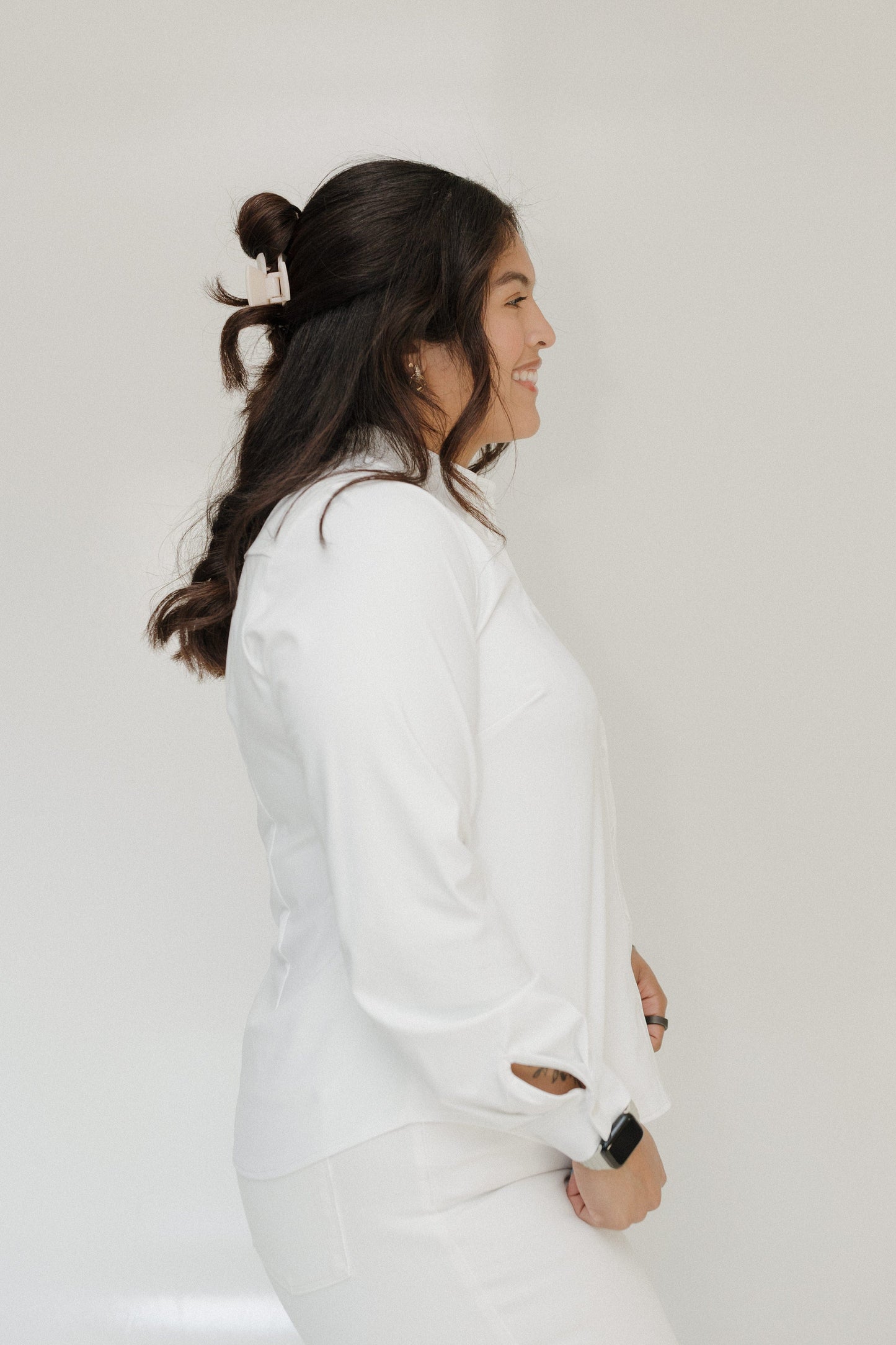 Woman wearing a white outfit against a plain background