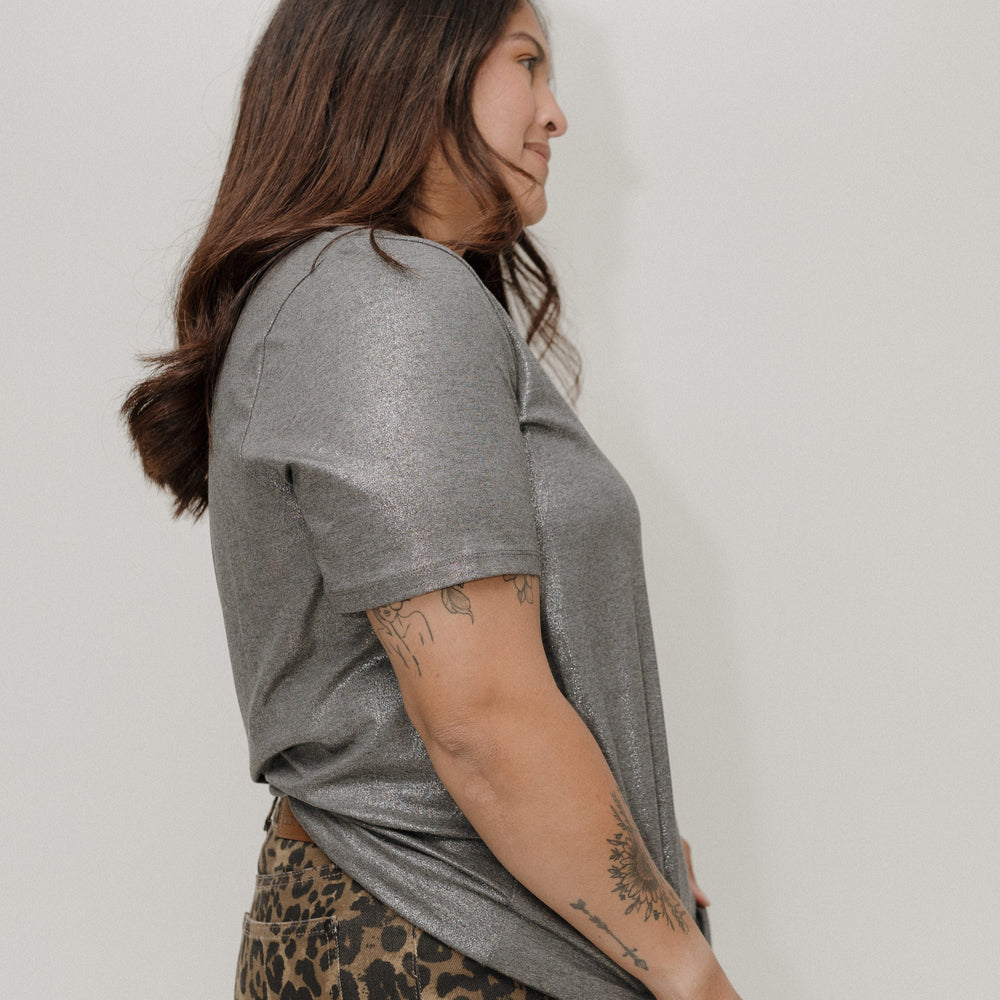 Woman wearing a gray t-shirt and leopard print skirt against a plain background