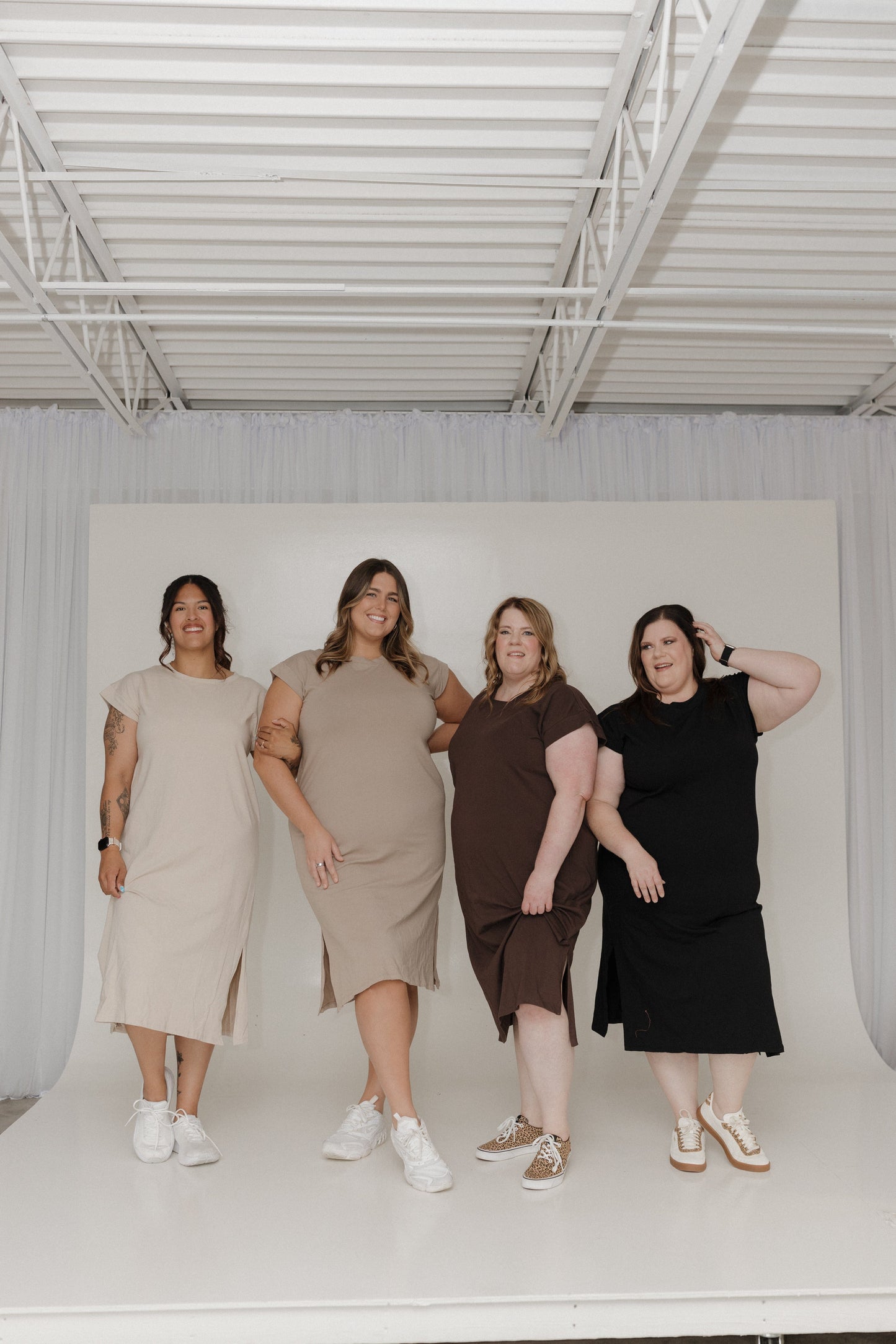Four women wearing dresses on a white background