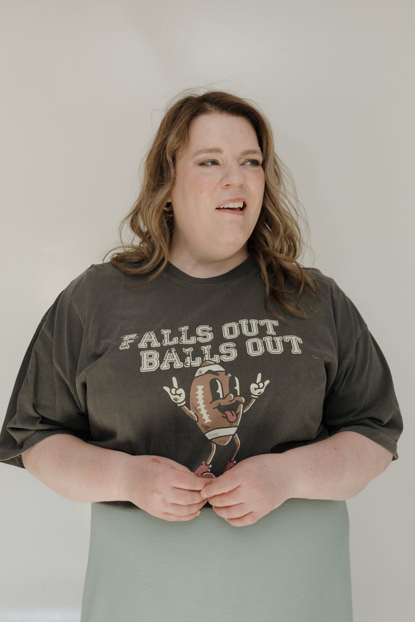 Person wearing a graphic t-shirt with text and design on a plain background