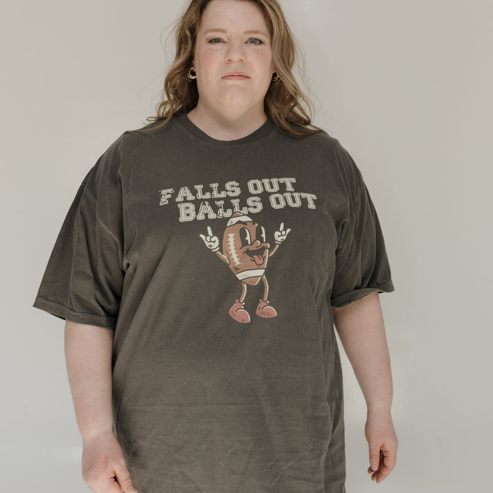 Person wearing a dark green t-shirt with graphic design and text on a plain background
