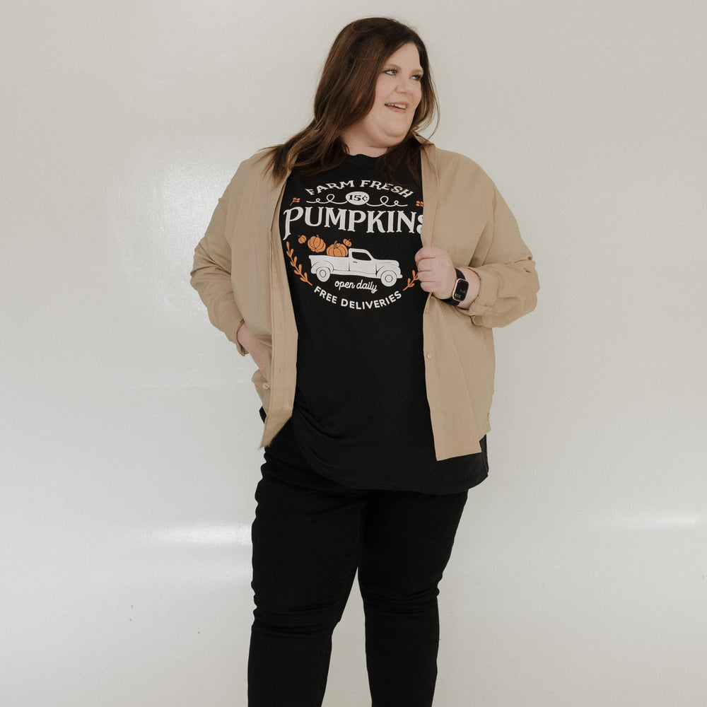 "FARM FRESH PUMPKINS" WITH TRUCK GRAPHIC TEE IN BLACK Woman wearing a black t-shirt with 'Farm Fresh Pumpkins' design against a plain background at Love Marlow