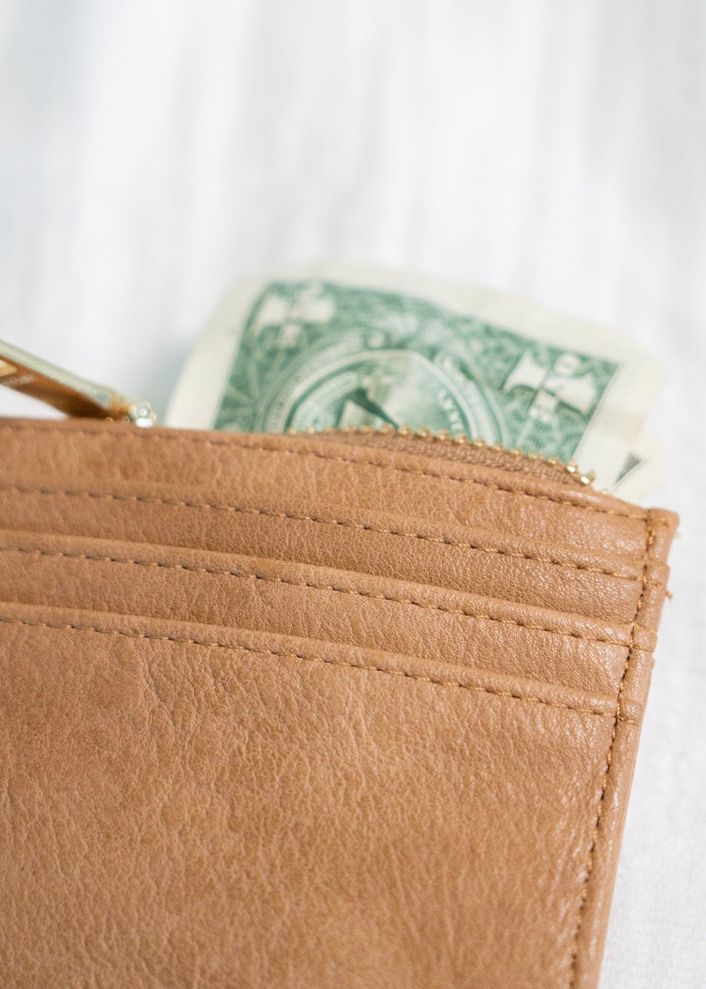 This stylish FAUX LEATHER WALLET IN MOCHA is perfect for carrying your cards and change while on the go. It features a fold-out design with a snap closure, card and ID slots, and a convenient zip change pocket. Enjoy quick access and organized storage with this classic wallet.