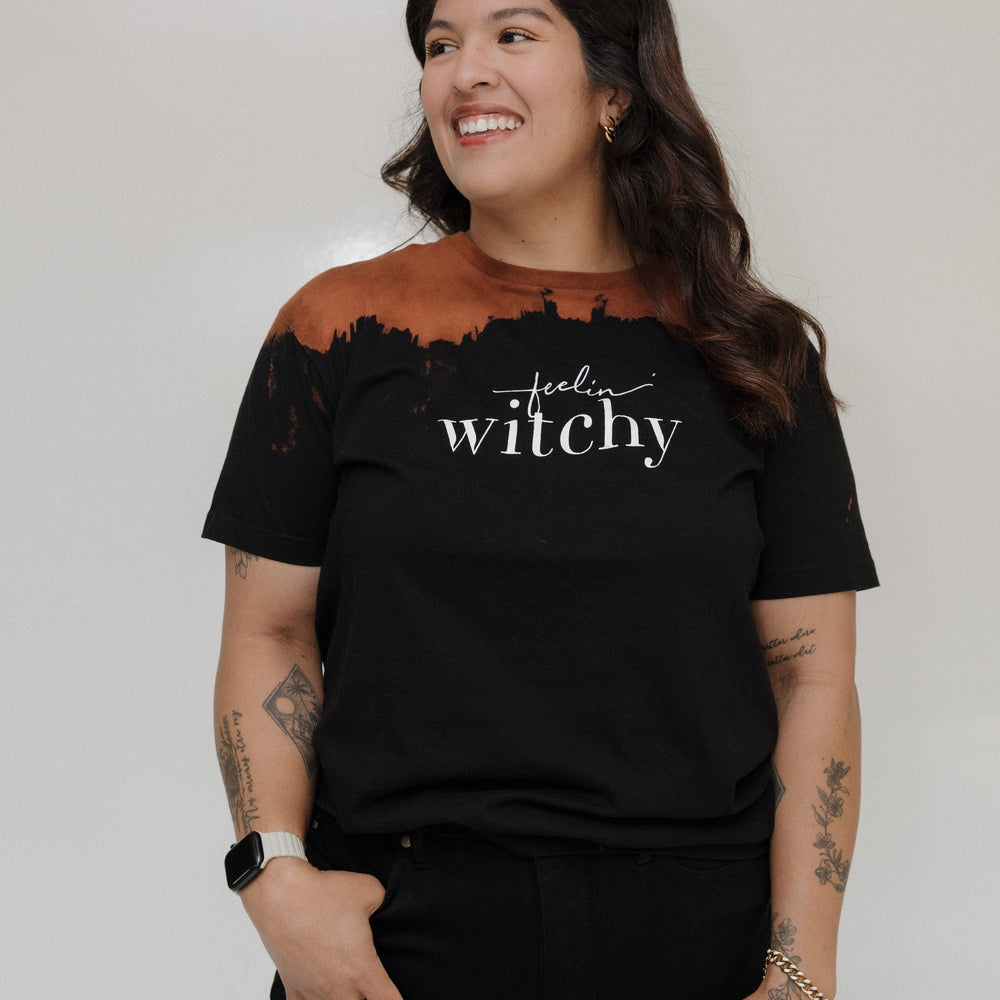 "FEELIN' WITCHY" GRAPHIC TEE
Woman wearing a black t-shirt with 'feel witchy' text on a plain background. Love Marlow Tee "Feelin Witchy"