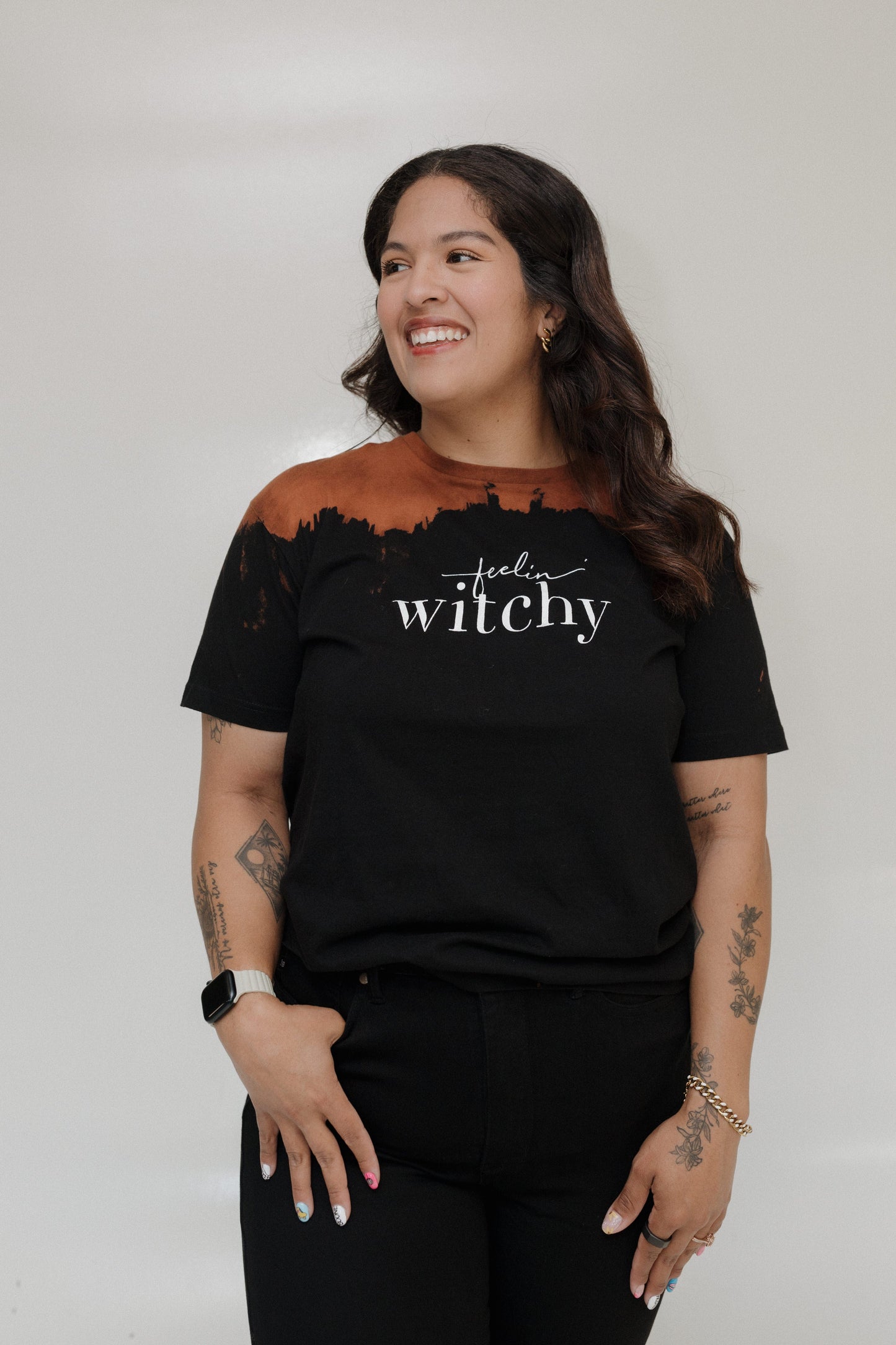 "FEELIN' WITCHY" GRAPHIC TEE
Woman wearing a black t-shirt with 'feel witchy' text on a plain background. Love Marlow Tee "Feelin Witchy"