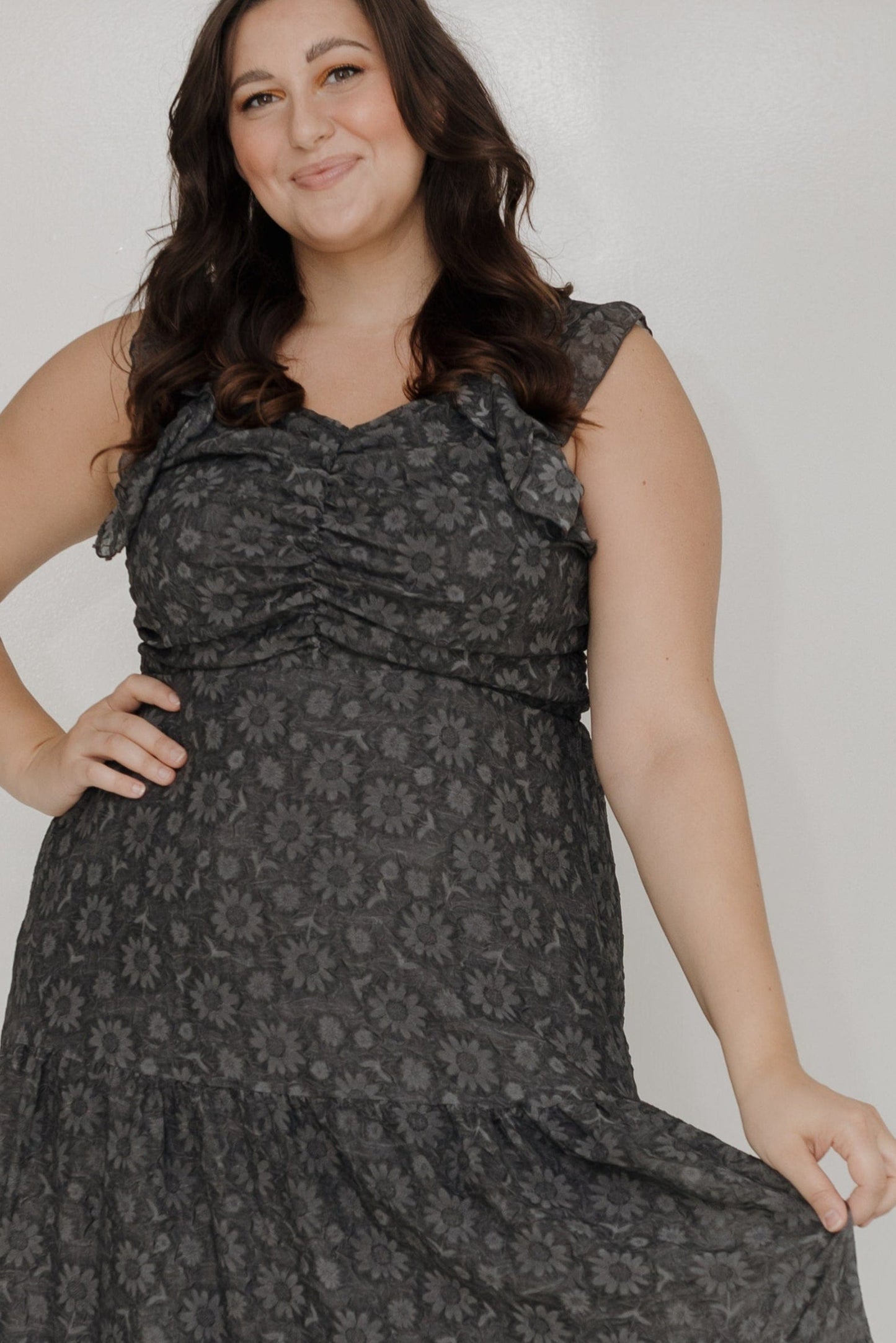 Woman wearing a black patterned dress against a white background