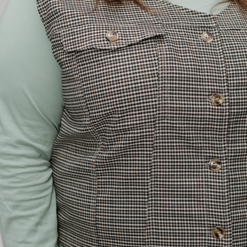 Houndstooth patterned vest worn by a person with a light green shirt underneath.
