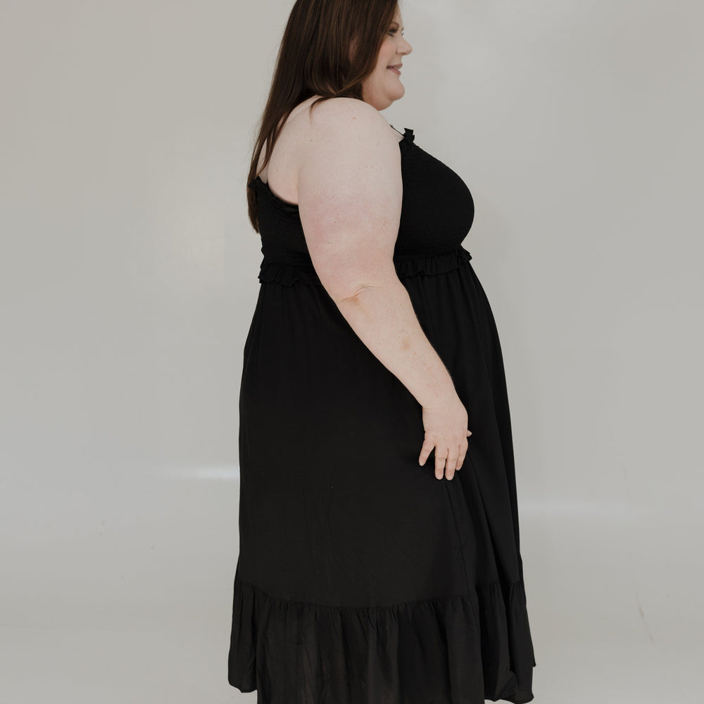 Woman wearing a black dress against a white background